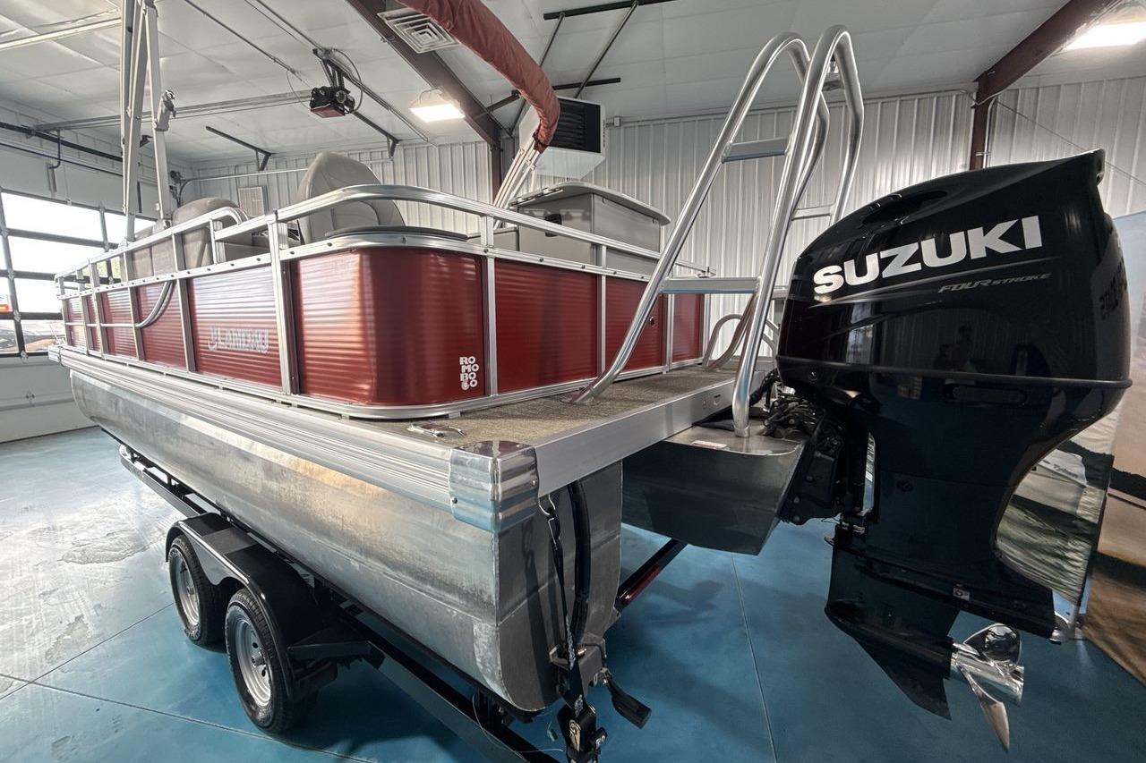 2022 Landau ALURE 232 pontoon boat with Suzuki outboard motor in a garage.