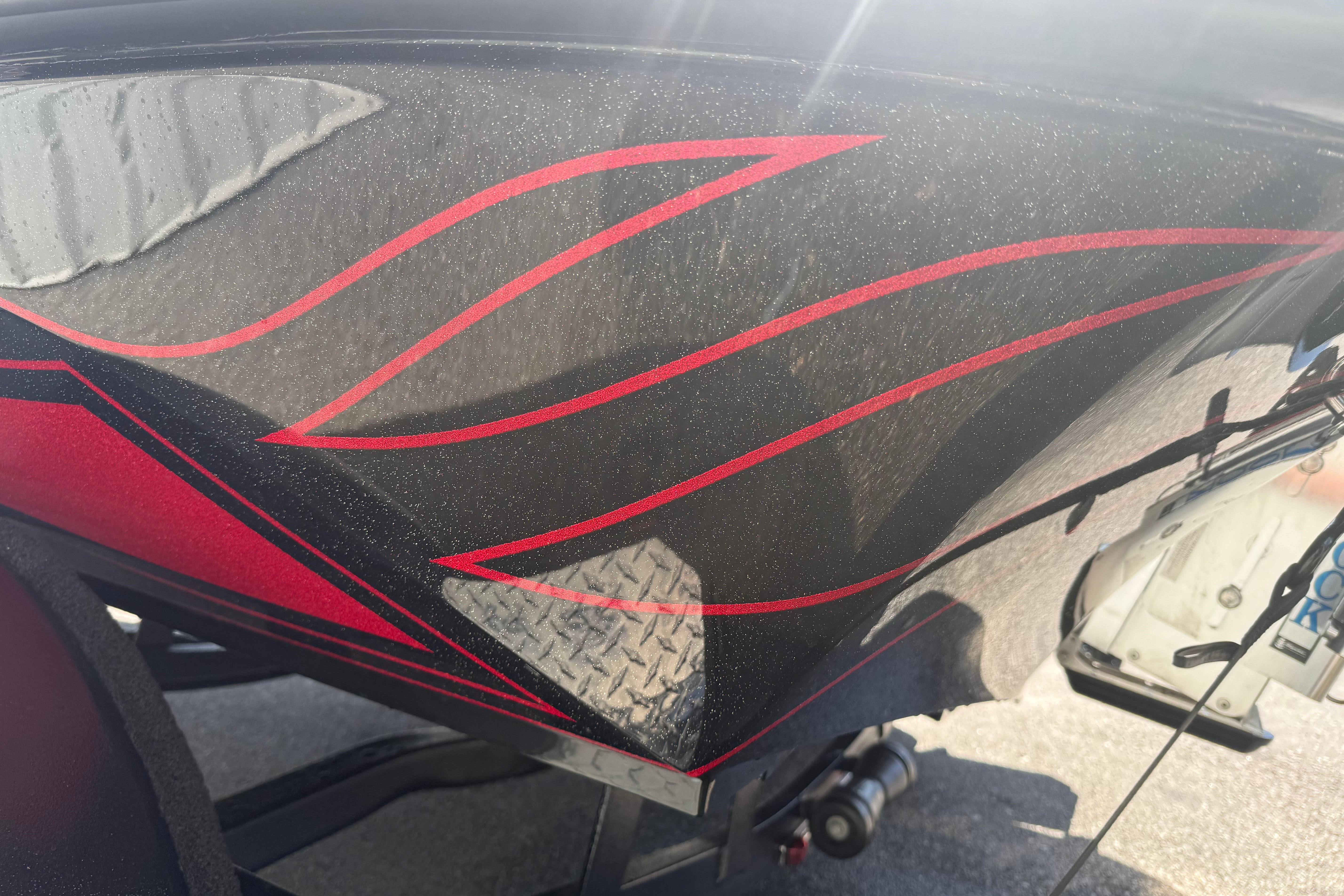 Close-up of 2027 Phoenix 919 ZXL boat with red and black flame design.