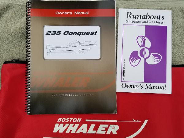 Owner's manuals for 2011 Boston Whaler 235 Conquest and Runabouts on a branded bag.
