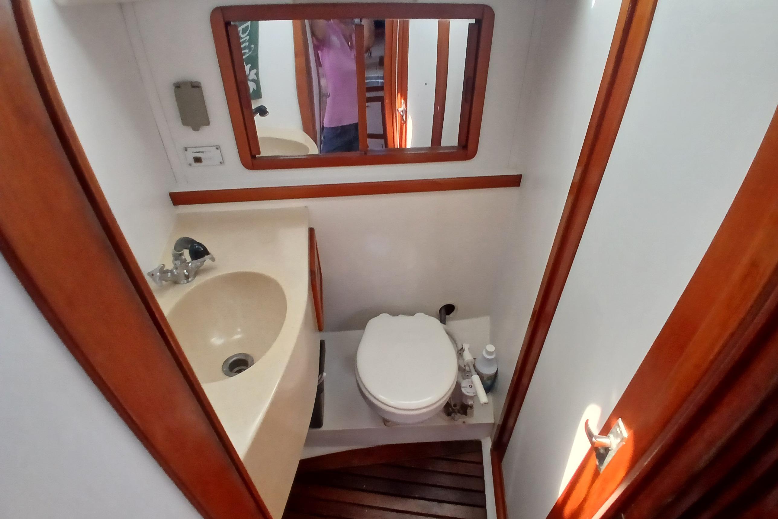 Bathroom interior of 1995 Catalina 42 MkII yacht with sink, toilet, and mirror.