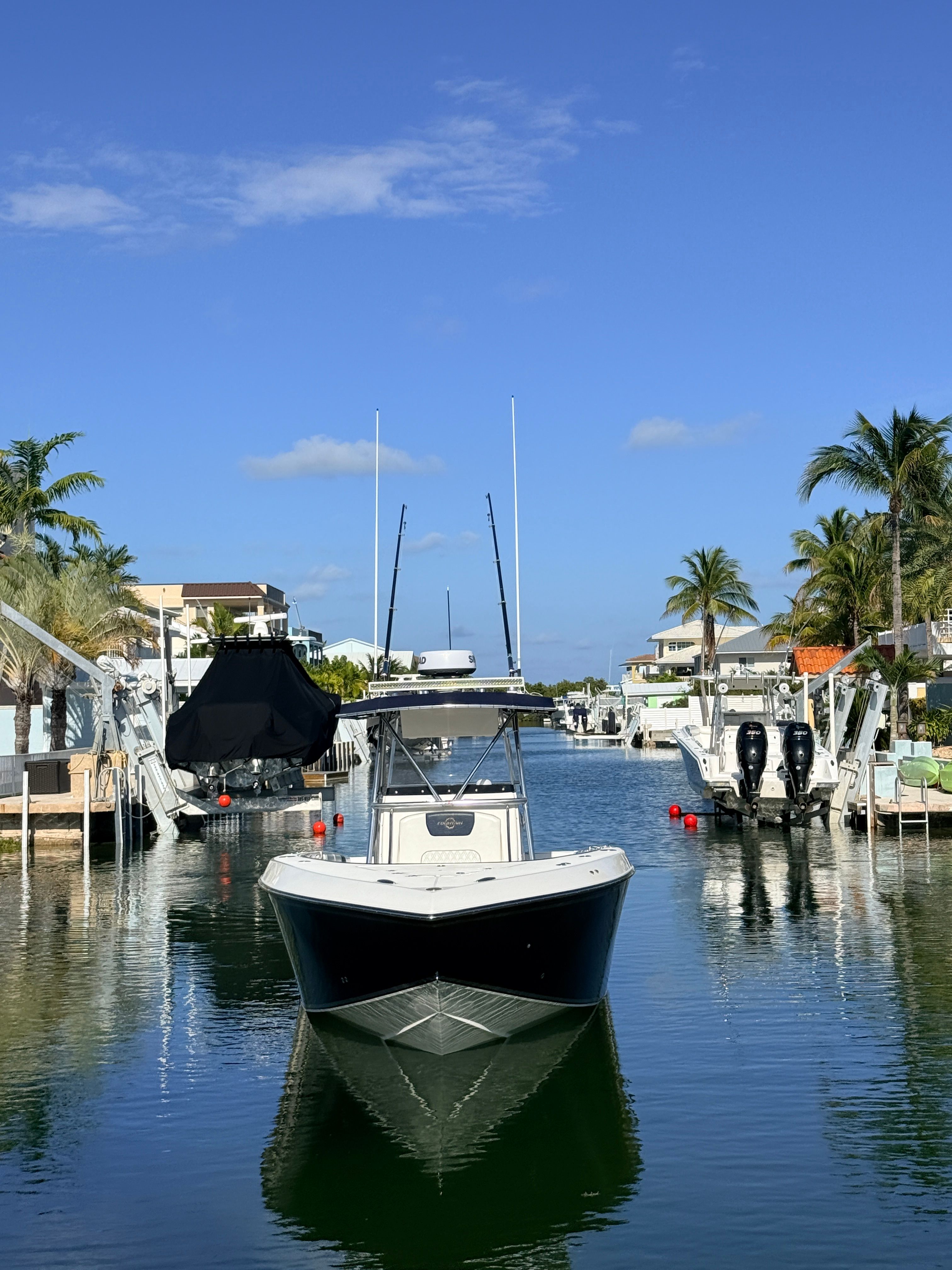 2007 Fountain 32 Center Console boat in sunny harbor.