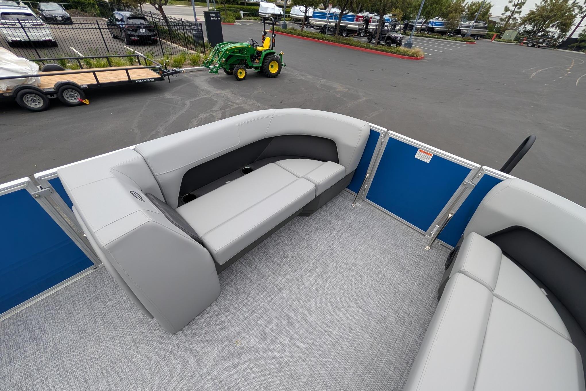 2026 Sun Tracker Party Barge 18 DLX interior with gray seating and blue paneling.
