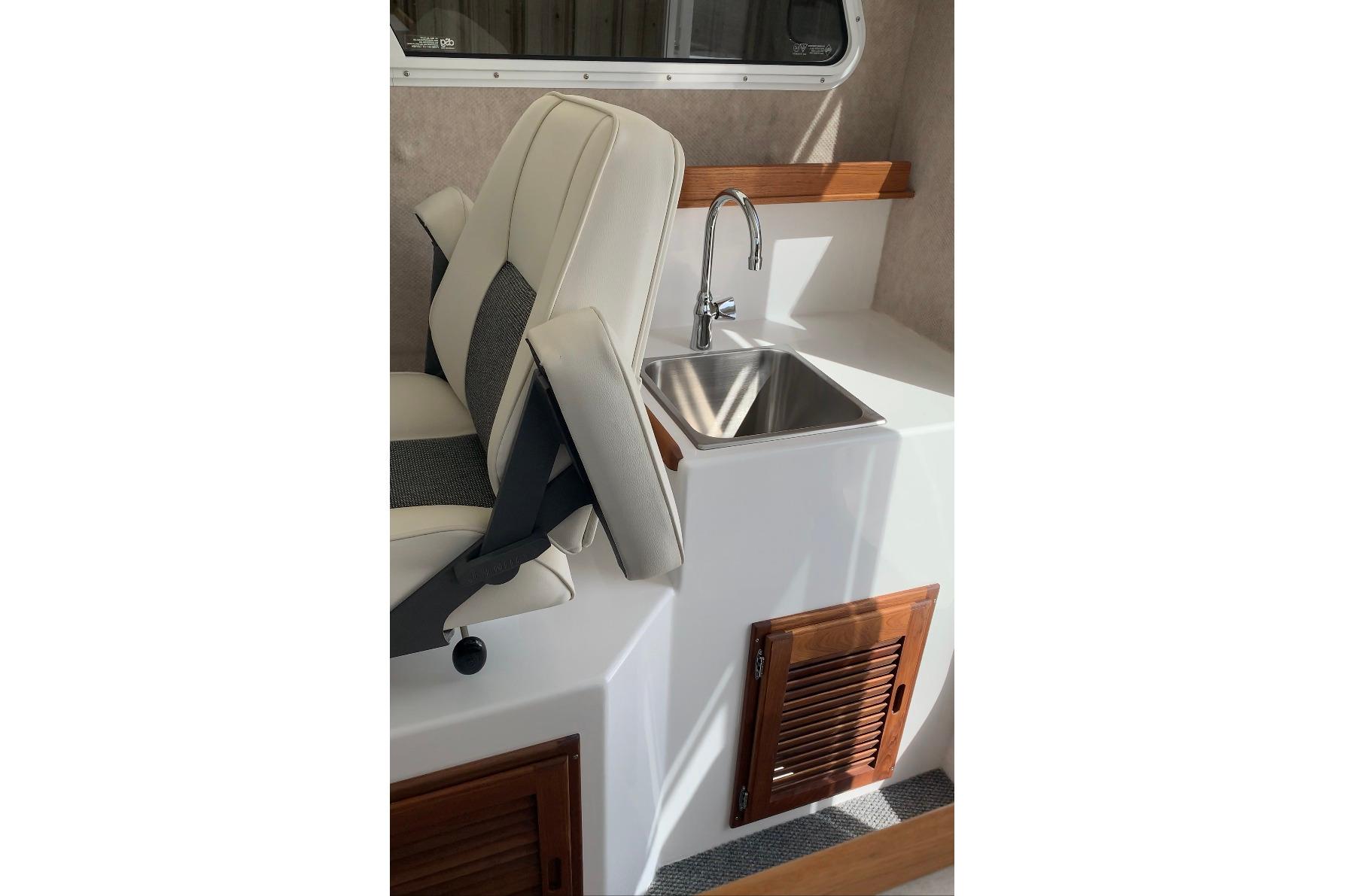 Interior of 2026 Sea Sport Kenai 2600 featuring a compact sink and seating area.