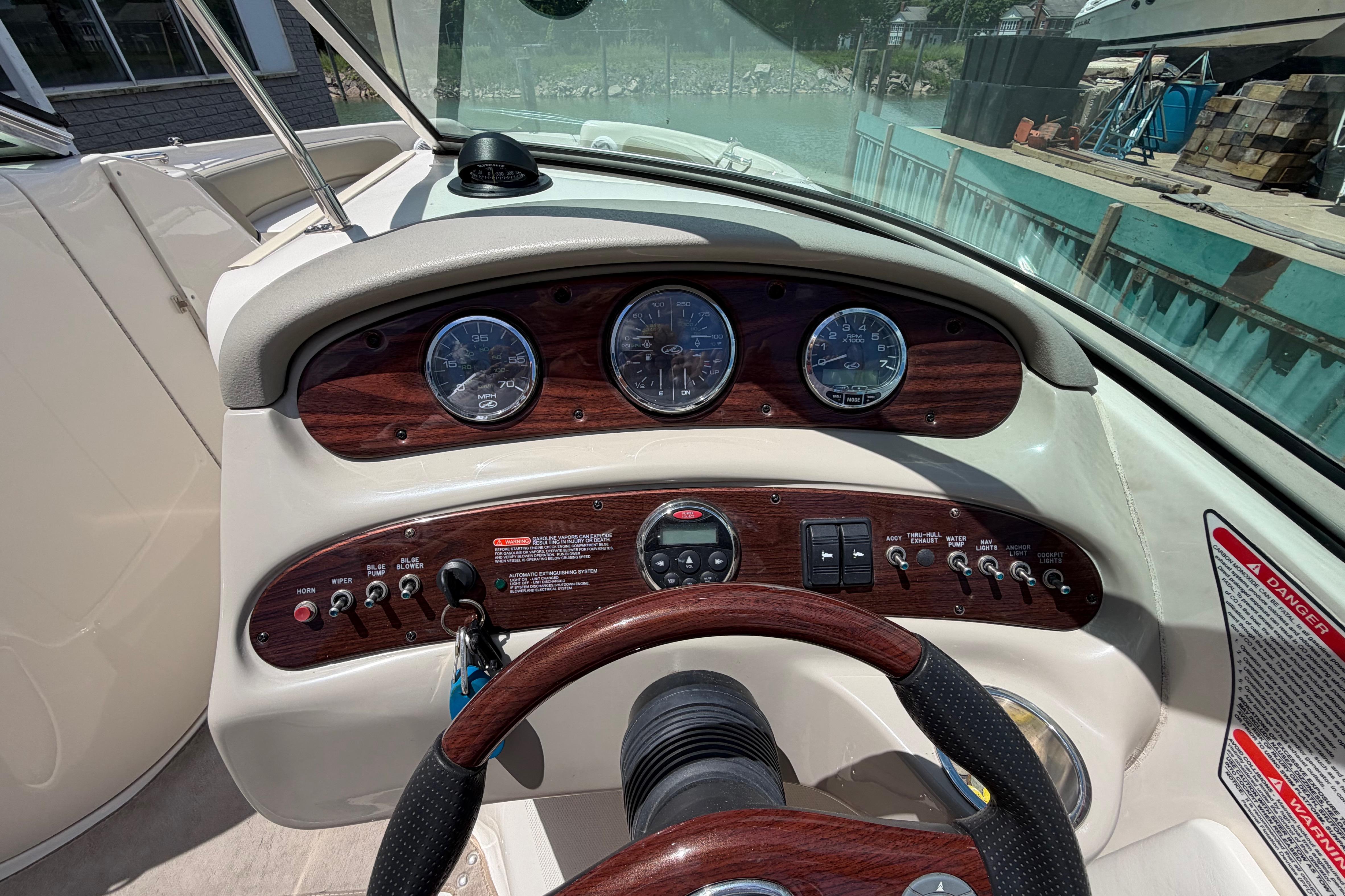 Dashboard of a 2004 Sea Ray 240 Sundeck boat with gauges and controls.