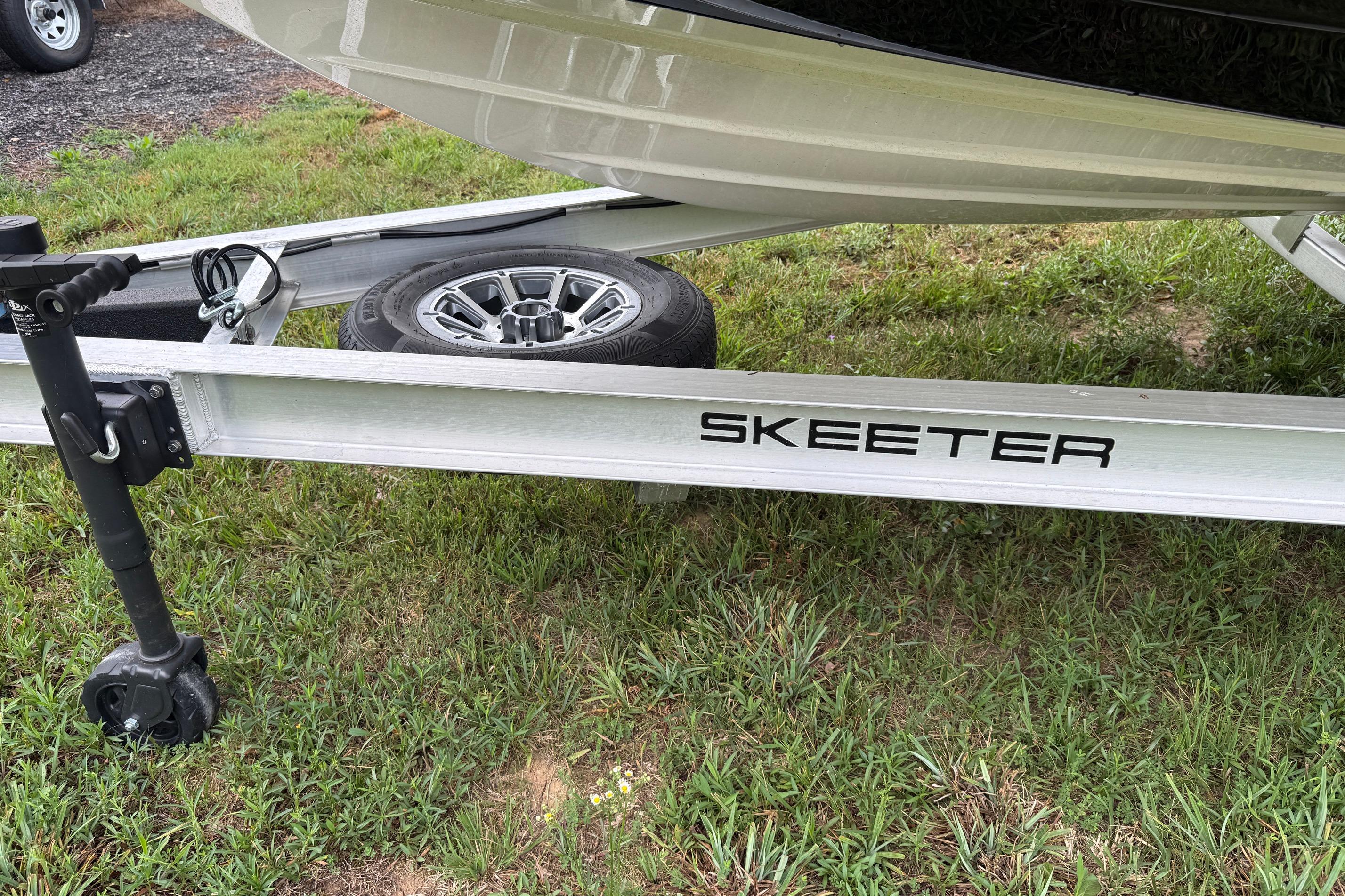 2026 Skeeter SX2350 boat trailer on grassy area, showcasing wheel and hitch.