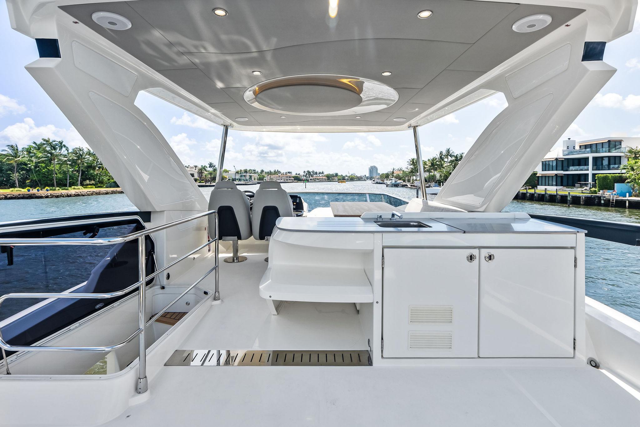 Luxurious 2023 Absolute 52 FLY yacht deck with modern amenities and scenic waterfront view.
