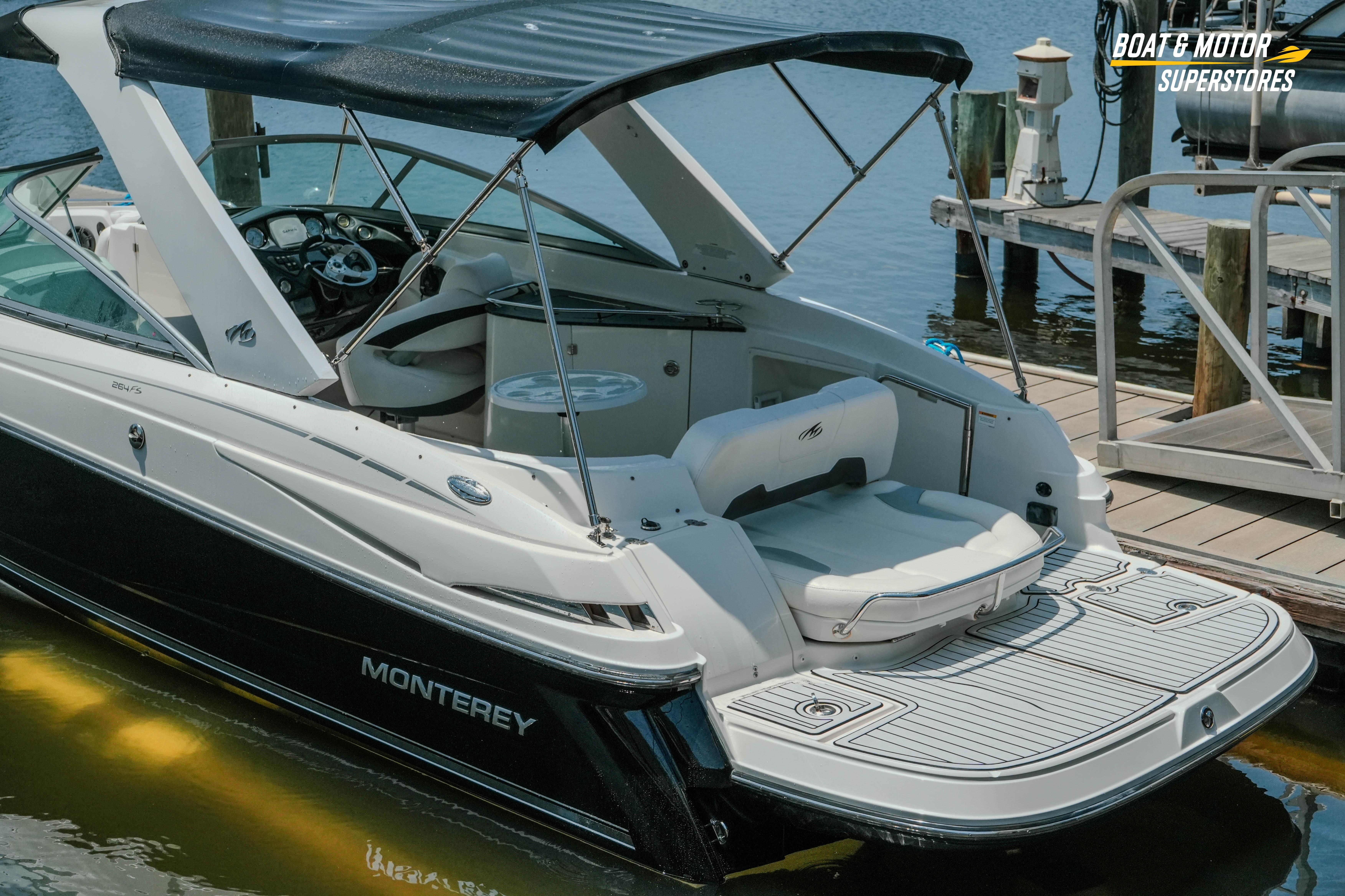 2012 Monterey 264FS boat docked, featuring sleek design and spacious seating area.