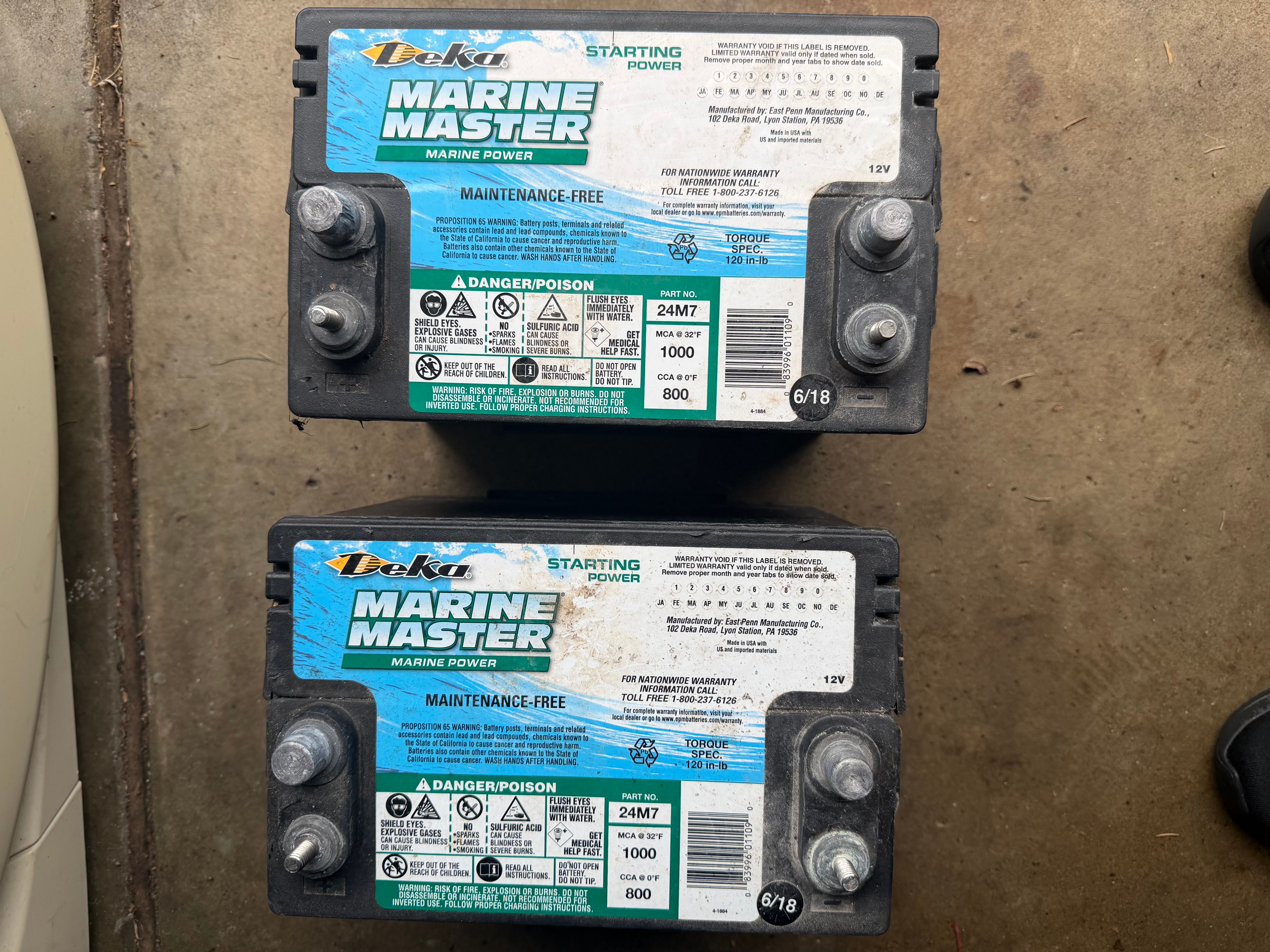 Two Deka Marine Master batteries on concrete floor, model 24M7, maintenance-free.