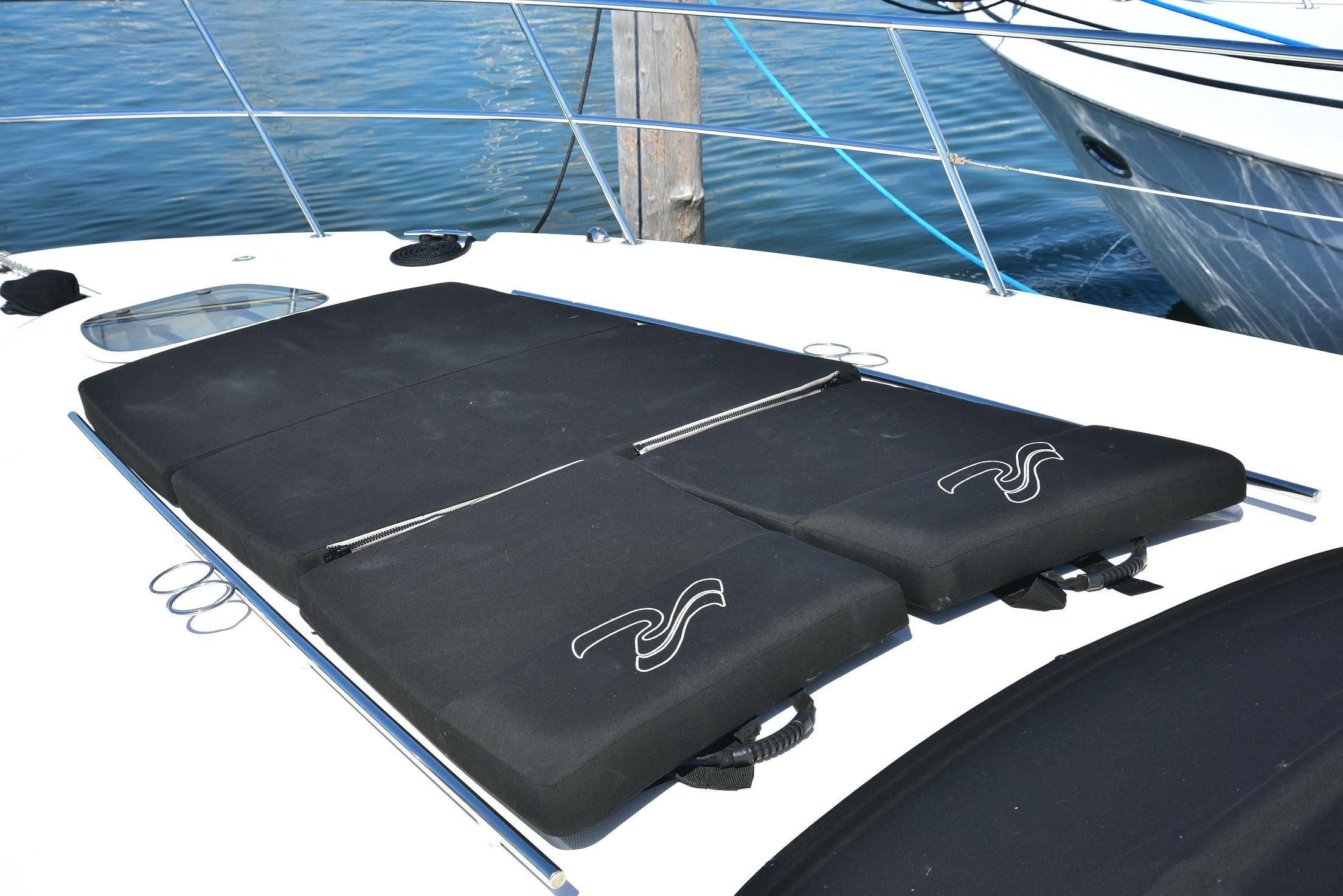 Sunbathing pads on 2013 Sea Ray 410 Sundancer yacht deck, near water.