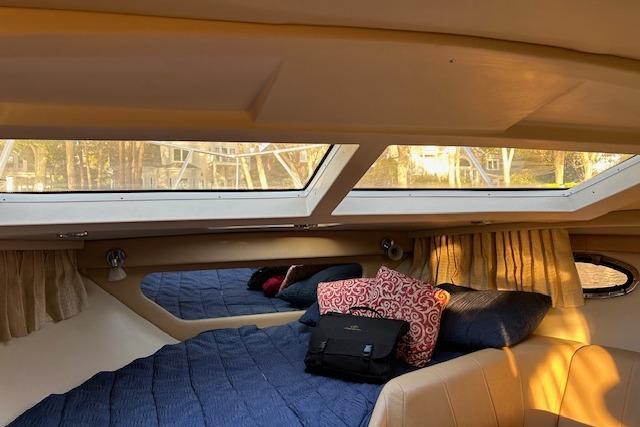 Interior cabin of 2010 Regal 3060 Window Express with cozy bedding and natural light.