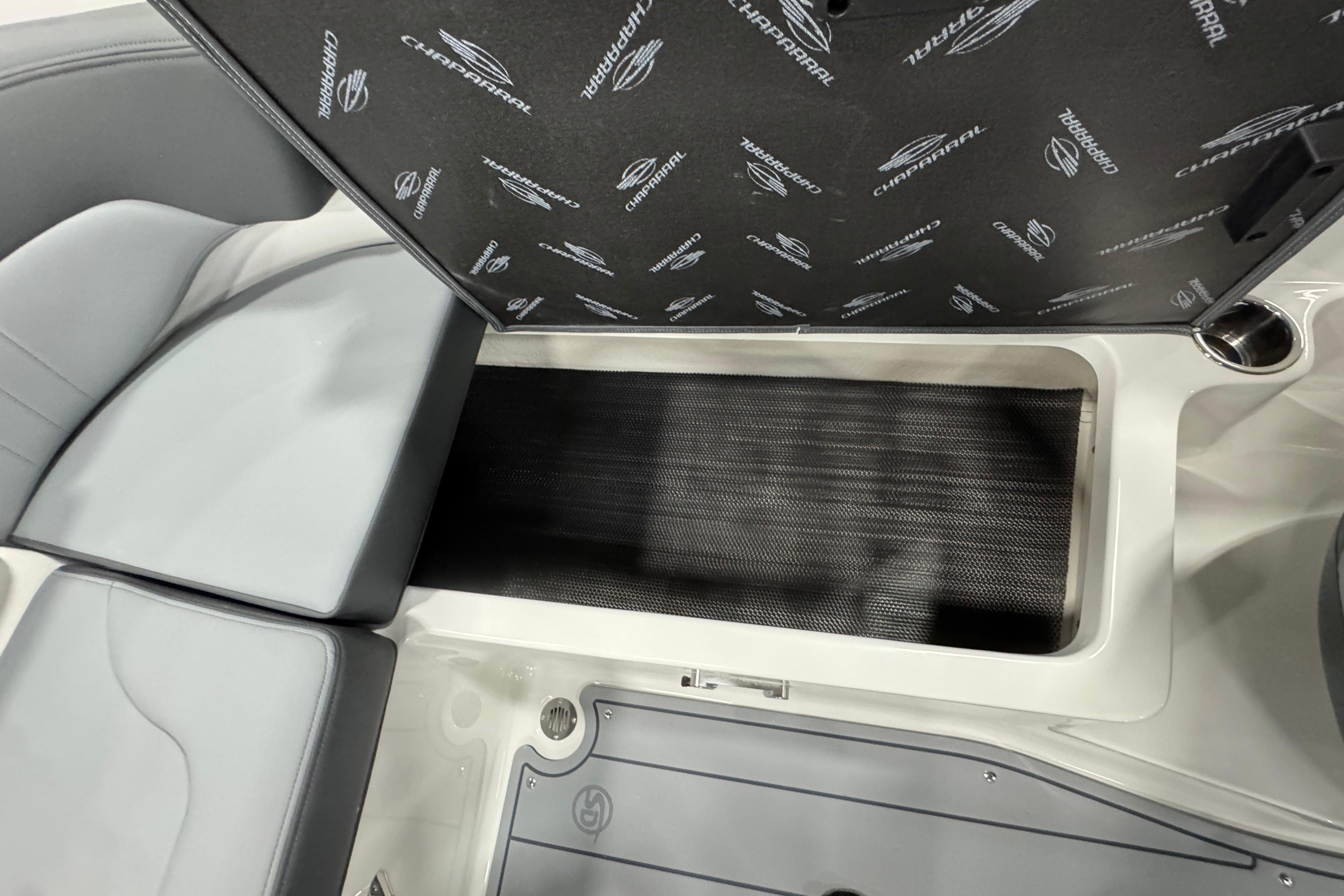 2026 Chaparral 23 SSi boat interior storage compartment with branded cover.