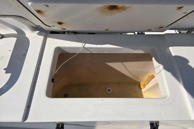 Open storage compartment on 2004 Robalo R235 Walkaround boat, showing interior details.