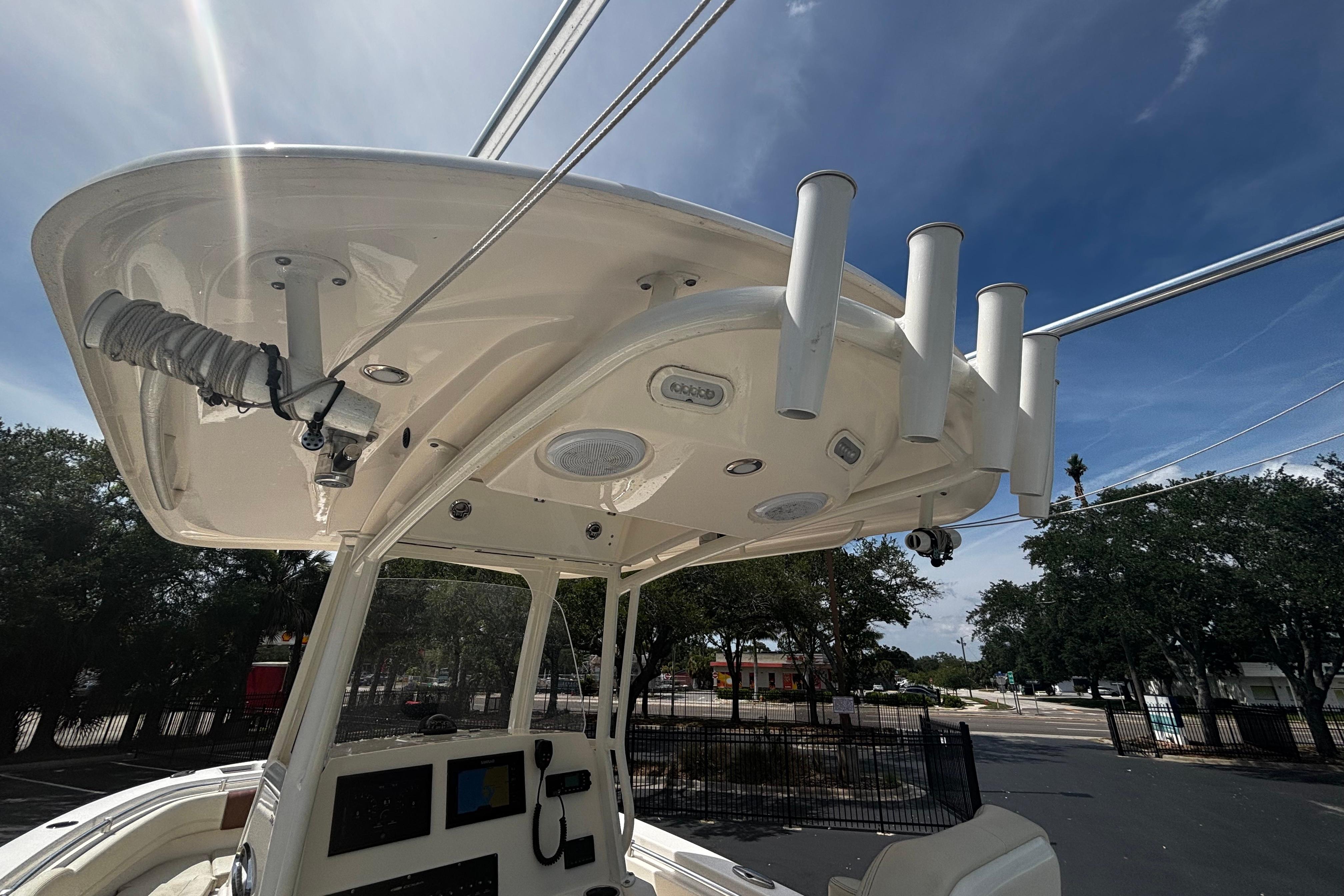 2023 Cobia 262 Center Console boat with T-top and rod holders under a clear sky.