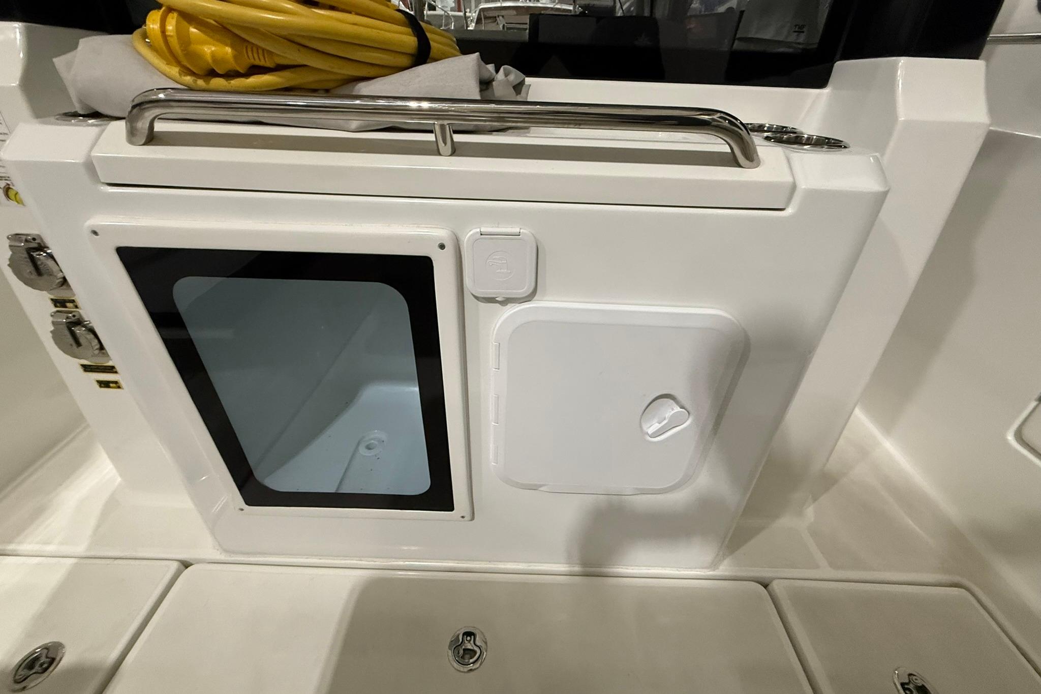 2024 Jeanneau NC Sport 795 Series 2 boat interior with storage compartments and yellow cable.