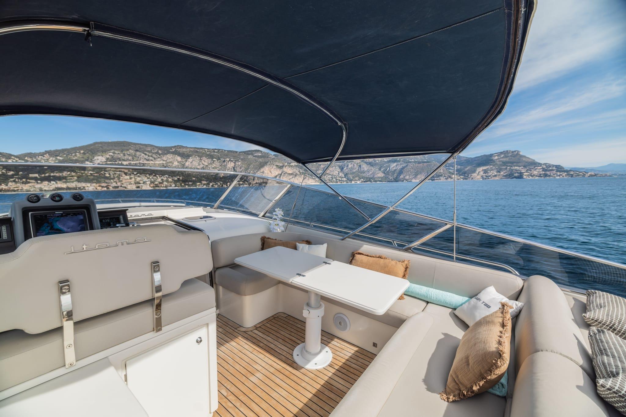 Luxurious 2009 Itama Forty yacht interior with seating, table, and scenic ocean view.
