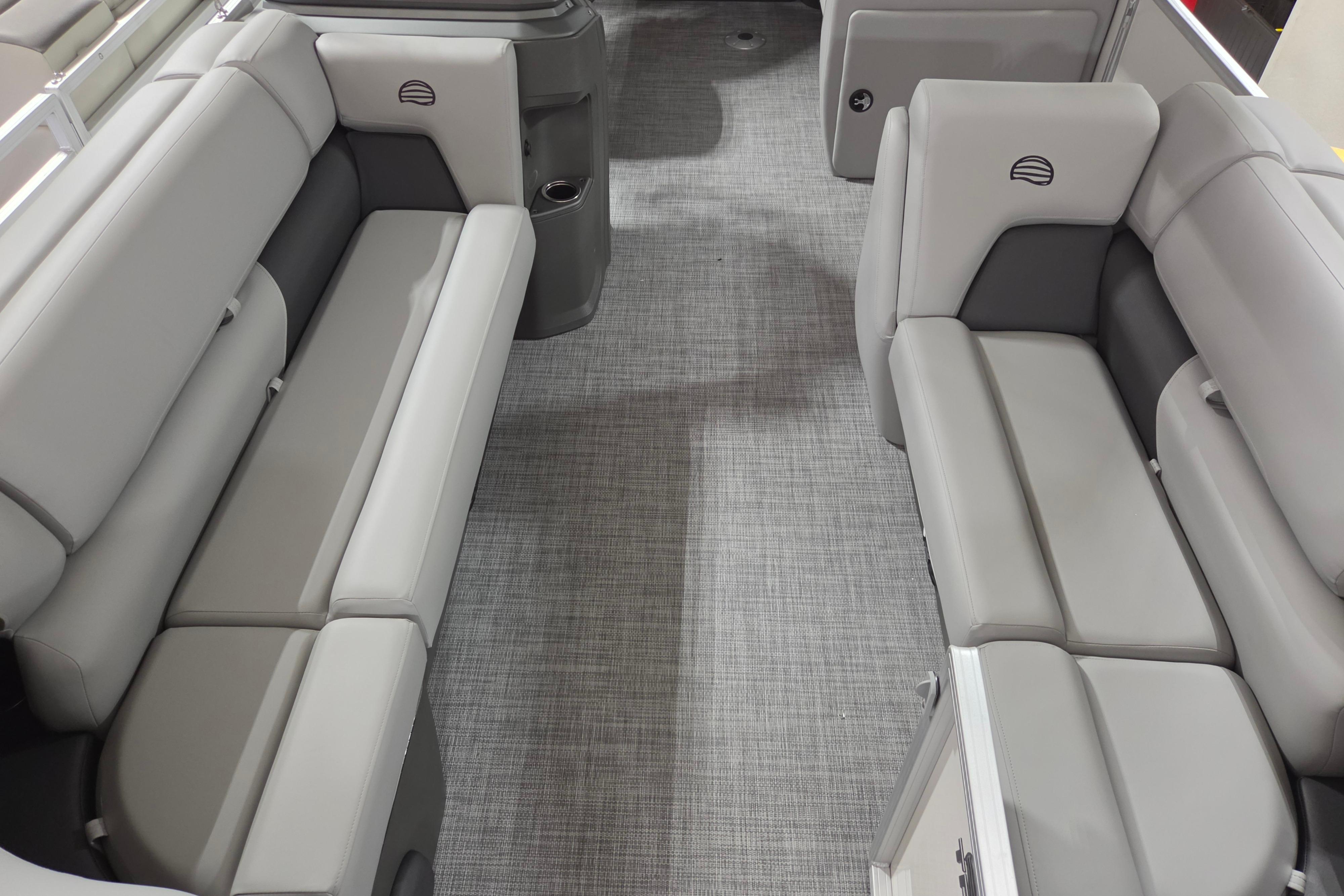 2026 Sun Tracker Party Barge 20 DLX interior with gray seating and carpeted flooring.