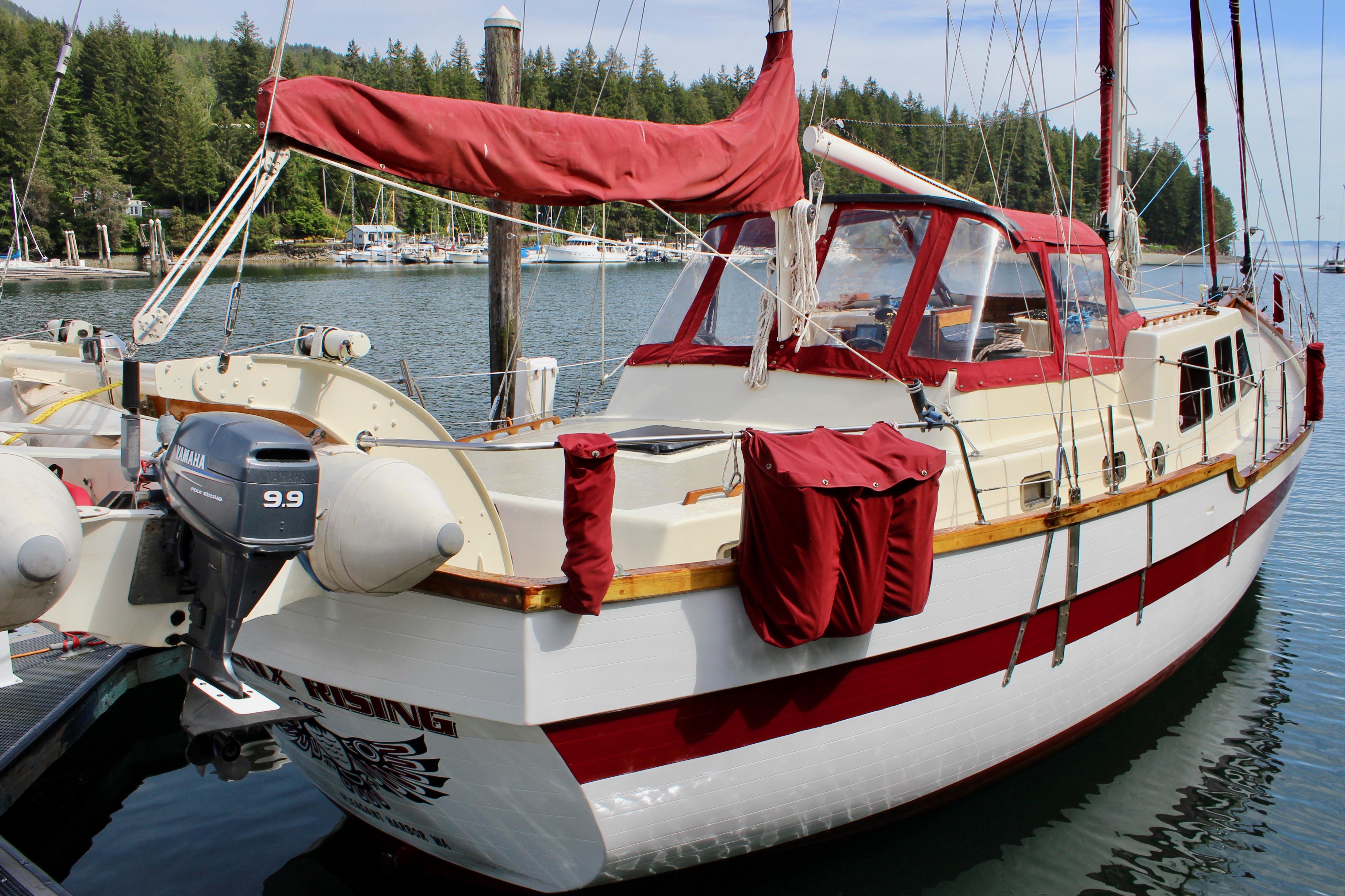 1981 Skookum 53 sailboat docked in a scenic marina with red accents.