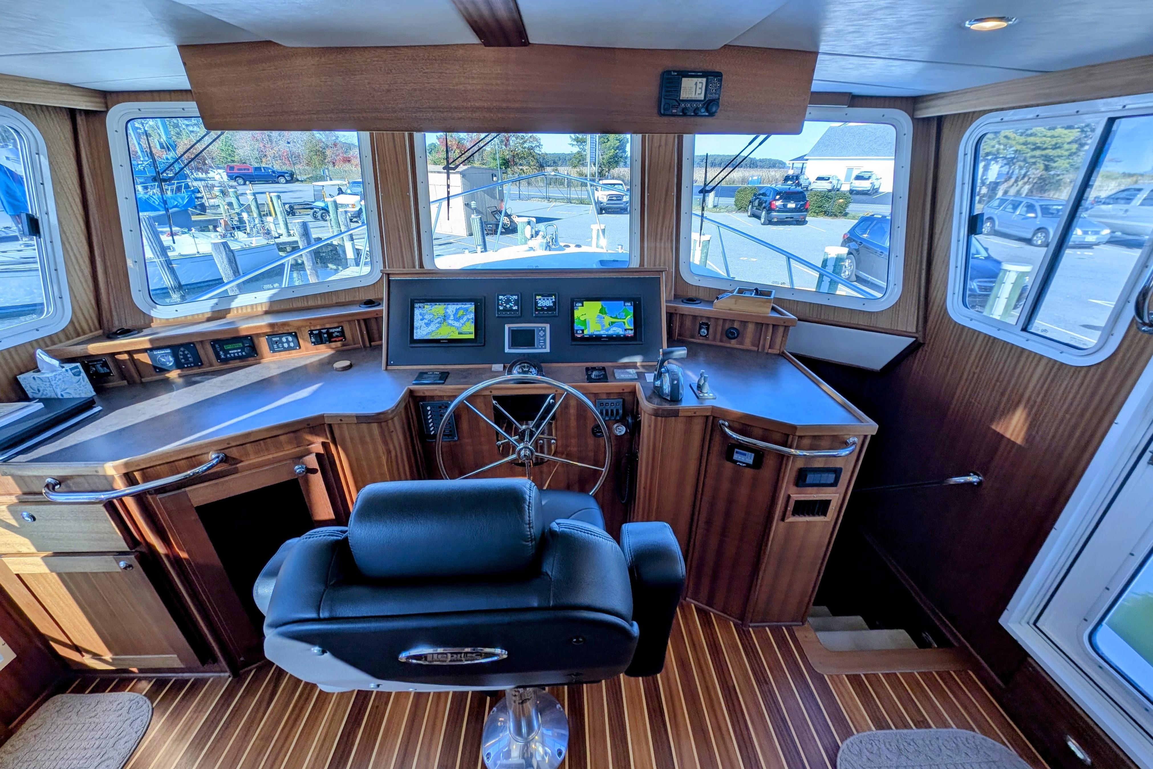 2015 American Tug 435 helm with navigation screens and wooden interior.