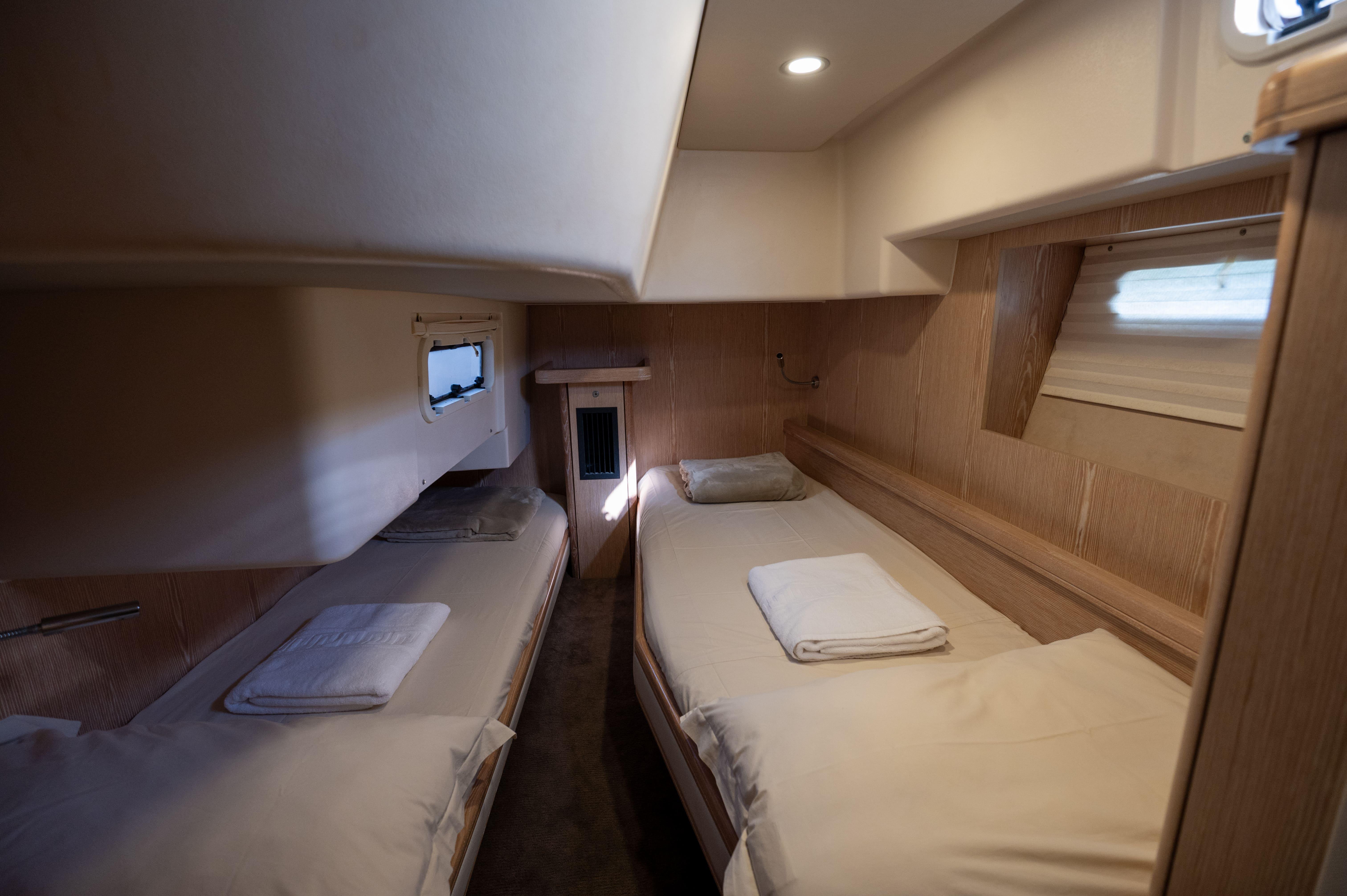 Cozy cabin interior of 2016 Moody Decksaloon 54 yacht with twin beds and soft lighting.