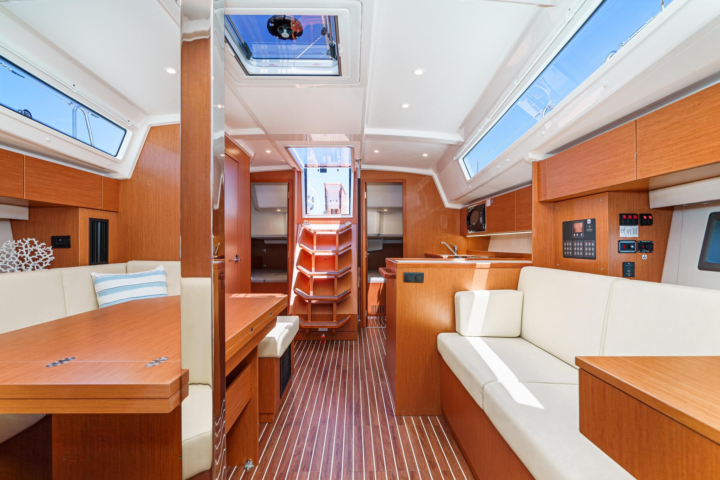 Luxurious interior of 2023 Bavaria C42 yacht with modern wood finish and ample seating.