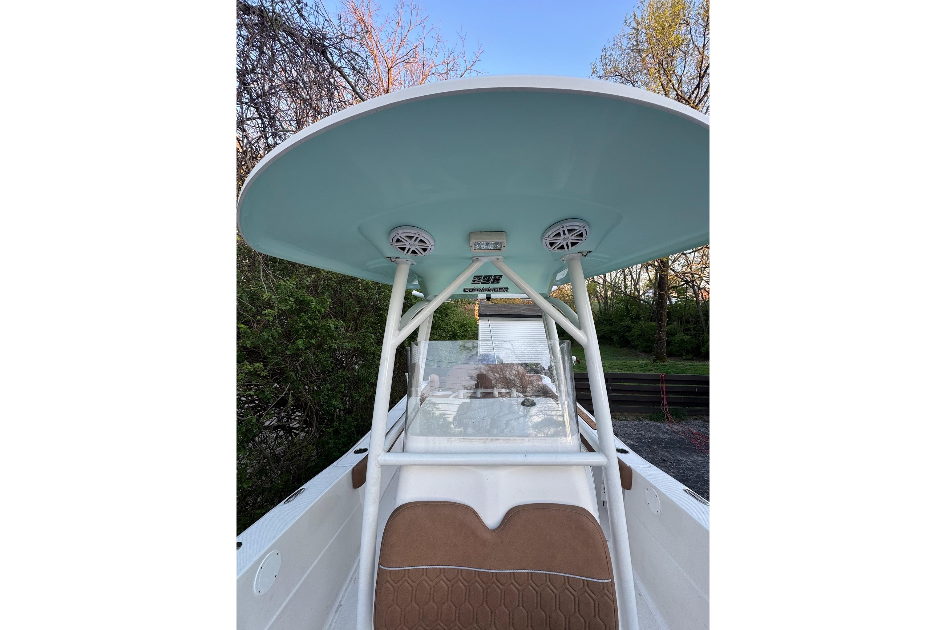2013 Sea Fox 246 Commander boat with T-top and speakers, surrounded by trees.