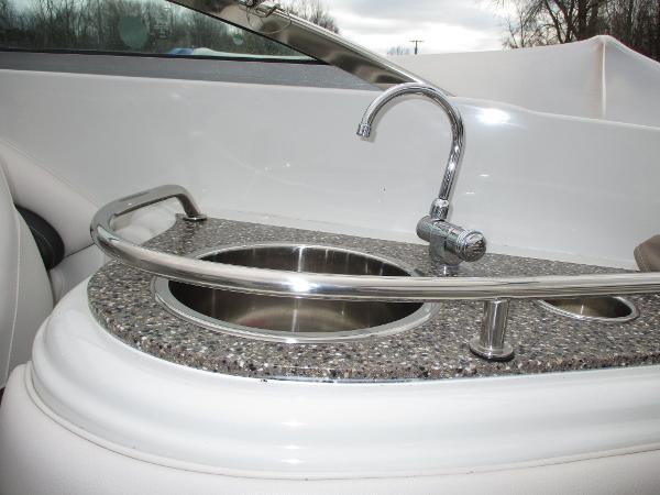 Crownline 285 SS 2015 boat kitchenette with stainless steel sink and faucet.