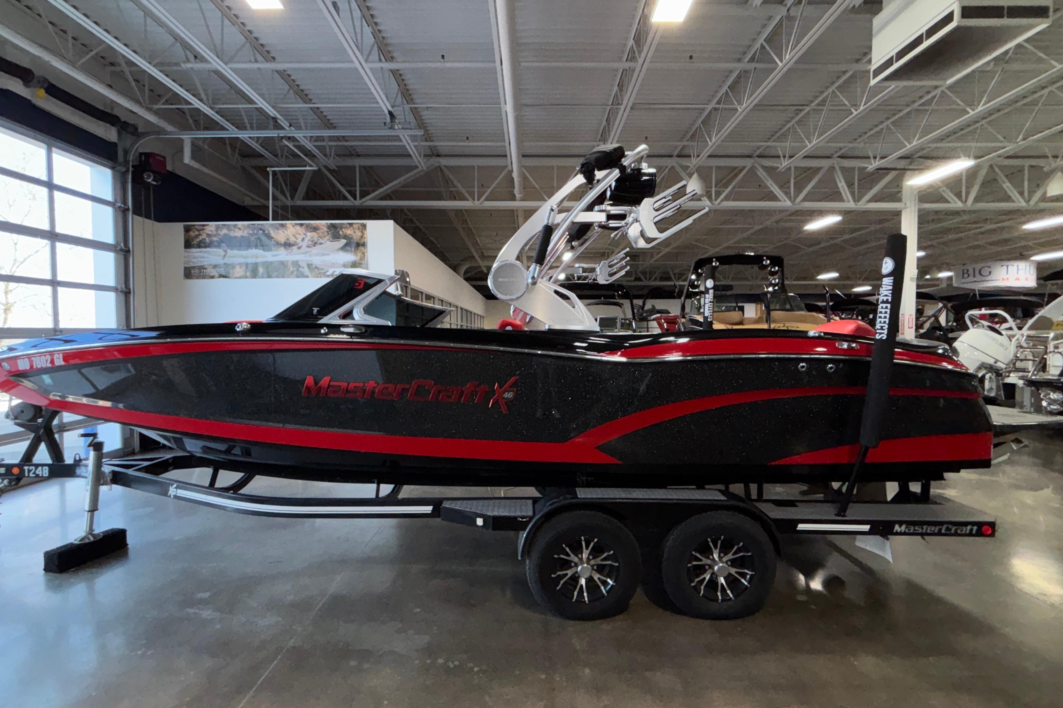 2017 MasterCraft X46 boat in showroom, black and red design, on trailer.