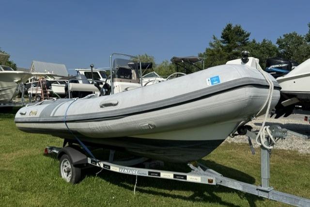 2022 North Atlantic Inflatables RIB420H boat on trailer, parked on grass.