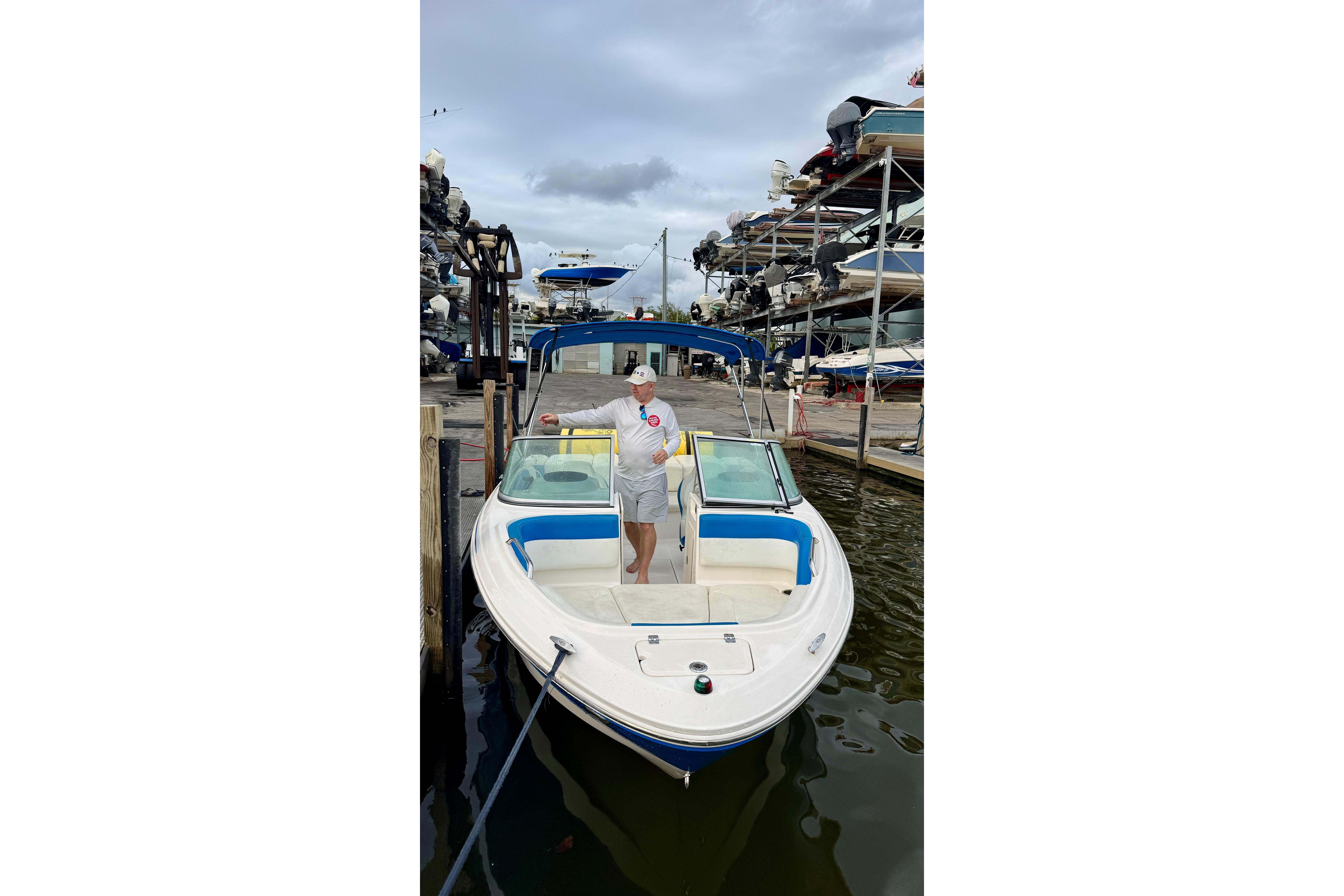 2018 Chaparral 21 H2O Sport boat docked at marina with person onboard.