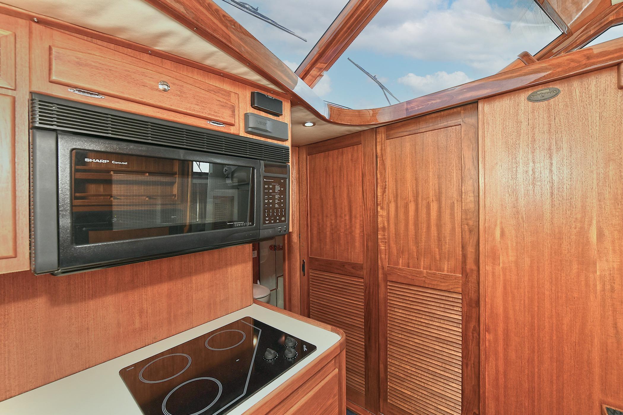 2005 San Juan Downeast Express kitchen with microwave, stovetop, and wooden cabinetry.