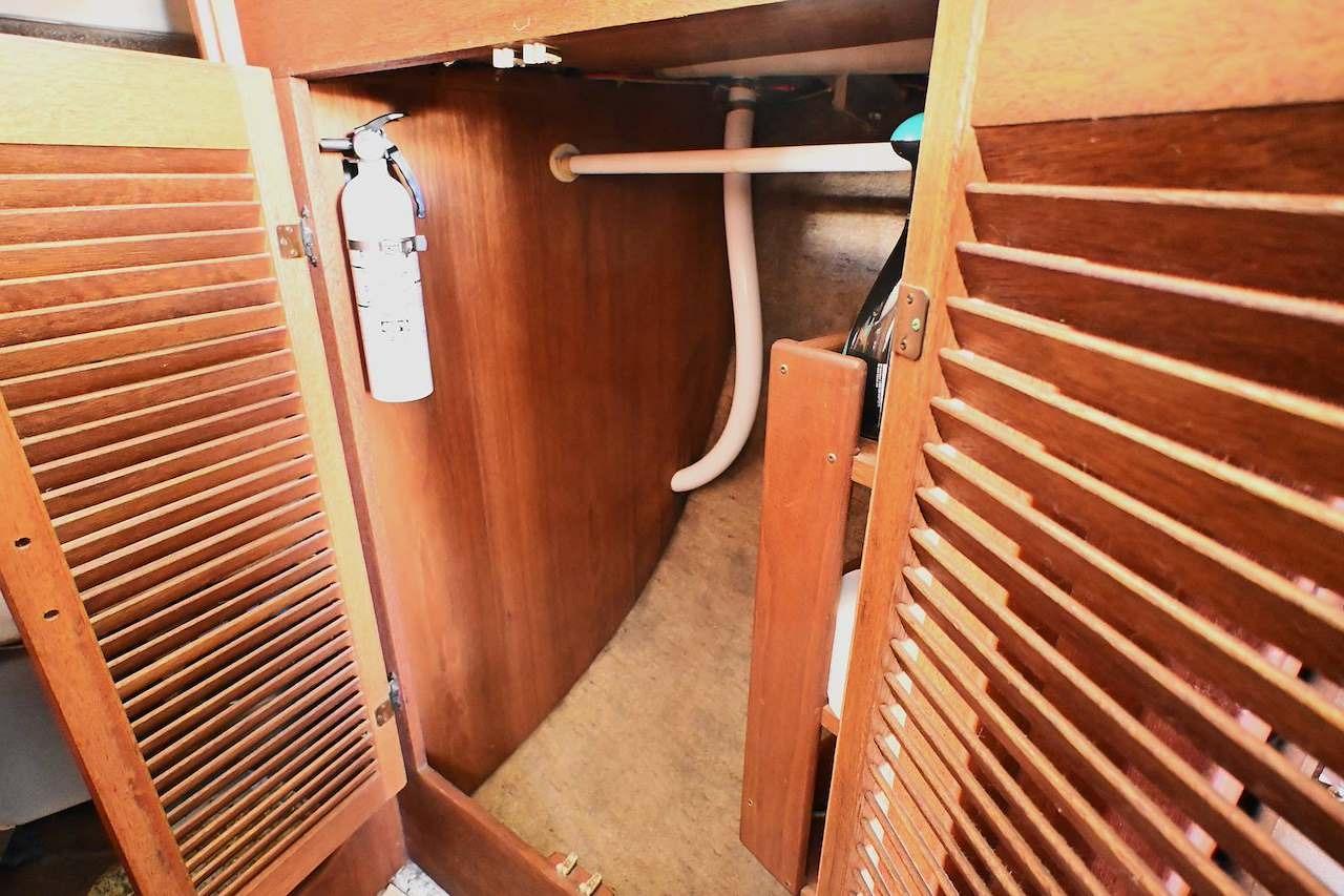 1977 Mercator Offshore boat interior with wooden cabinetry and fire extinguisher.