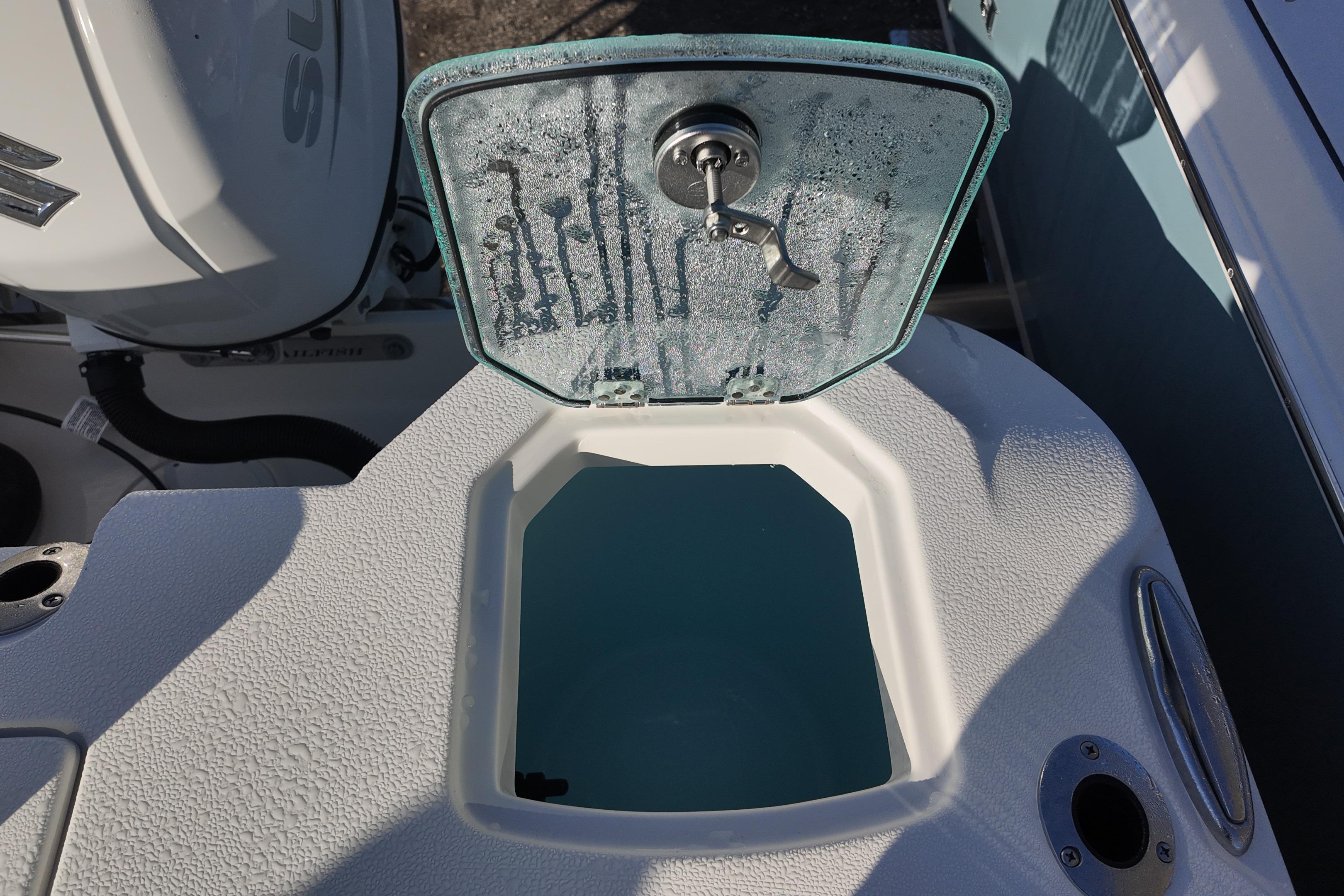 Open hatch on 2026 Sailfish 272 CC boat, revealing storage compartment.