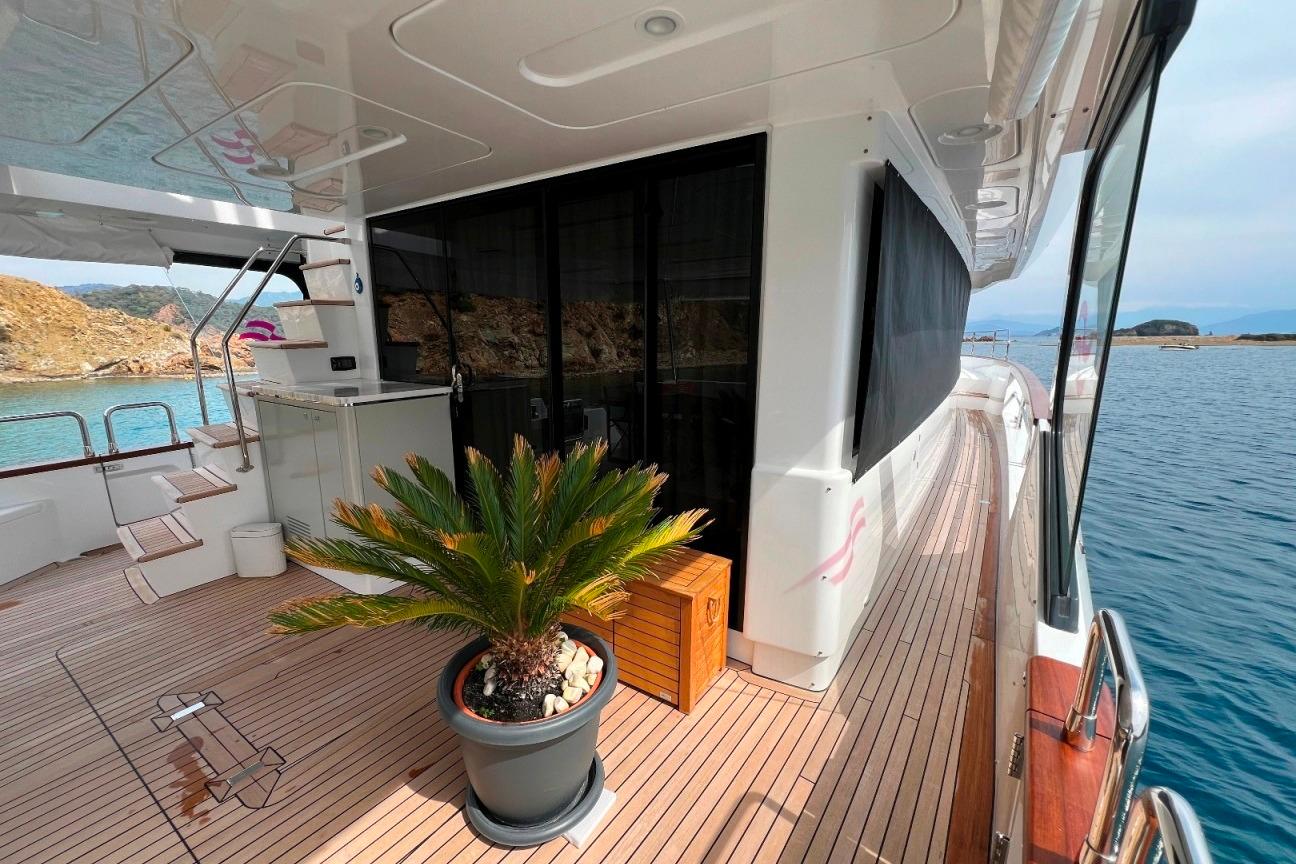 Luxurious 2024 Sirena 68 yacht deck with potted plant, overlooking serene waters.