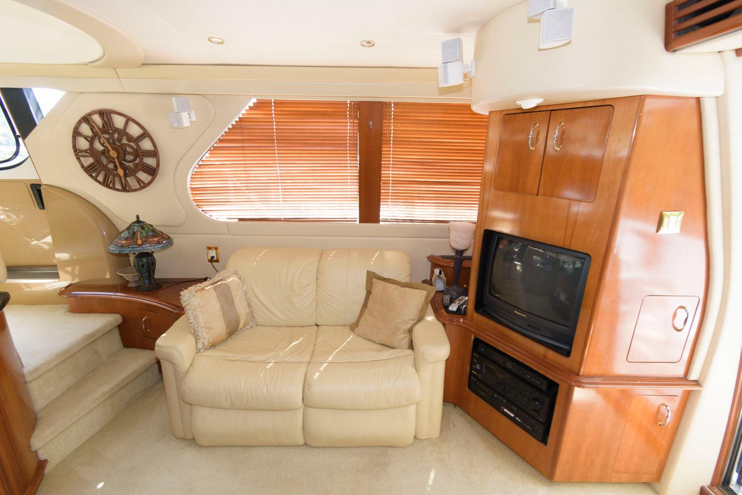 Luxurious interior of 2003 Carver 450 Voyager Pilothouse with leather sofa and entertainment center.
