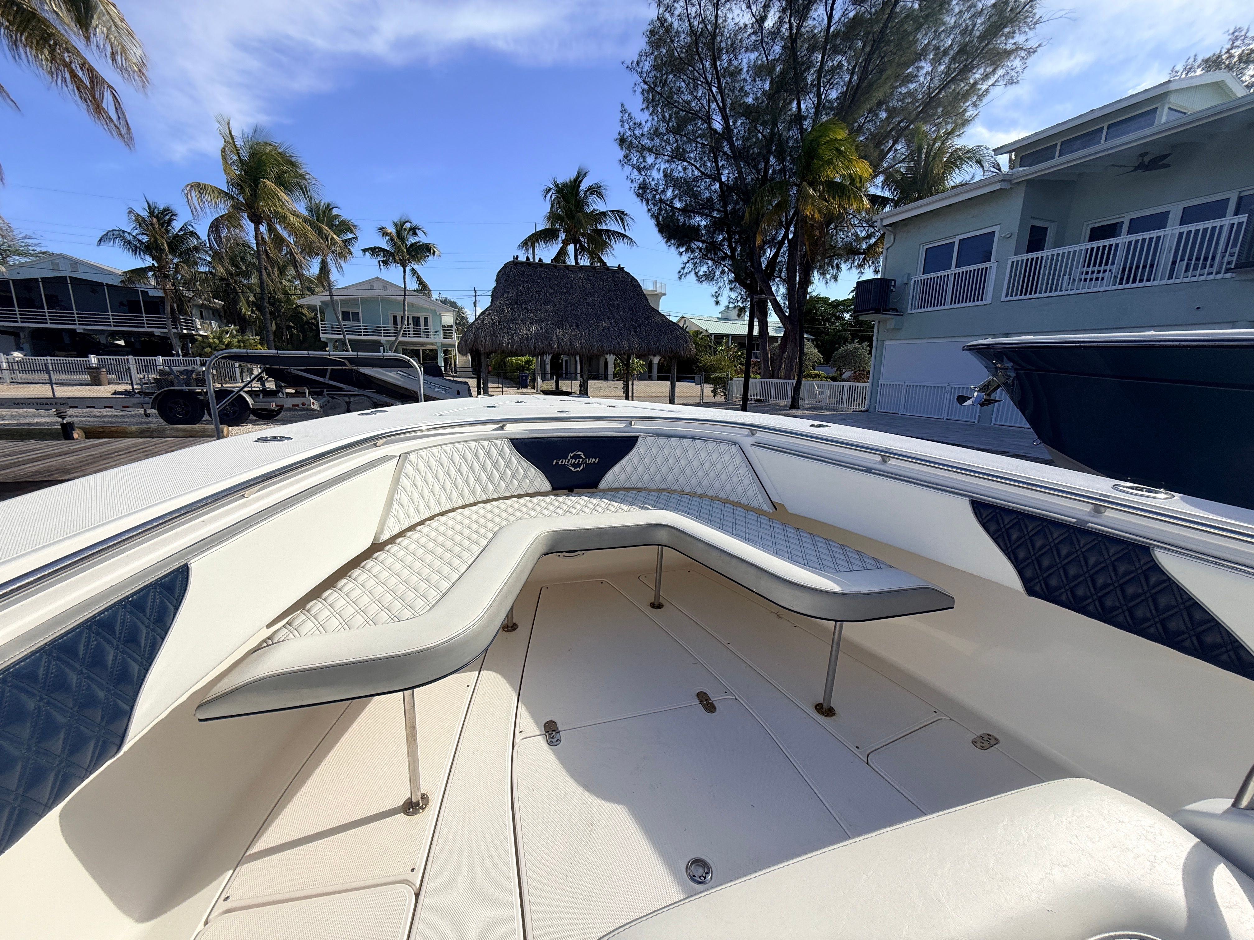 2007 Fountain 32 Center Console boat with cushioned seating and palm trees in the background.