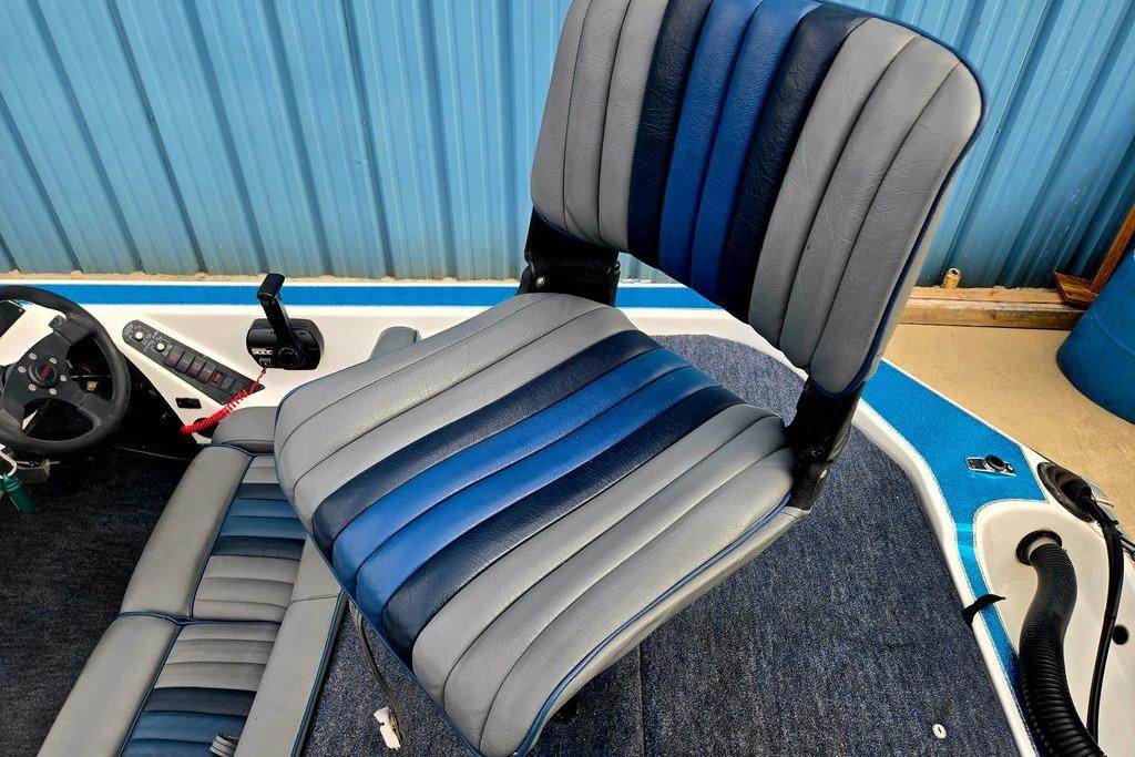 1996 Champion 181 SX boat interior with blue and gray seating, steering wheel, and controls.