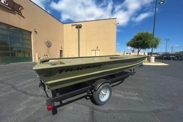 2026 Tracker Grizzly 1648 Utility boat on trailer, parked outside a building under a clear sky.