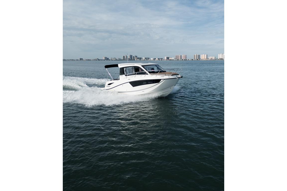 2026 Trophy T25EX EXPLORER OB boat cruising on open water with city skyline backdrop.