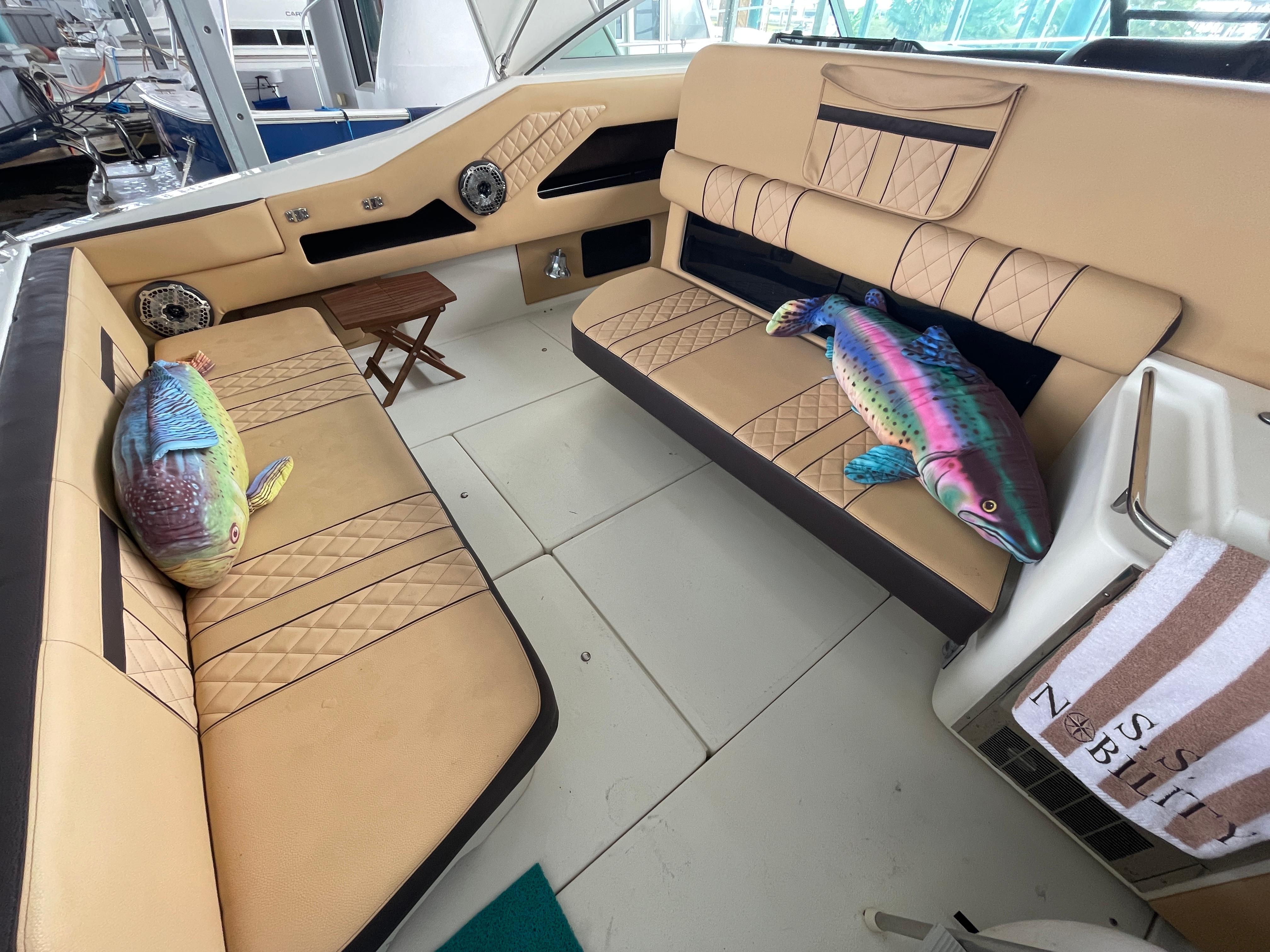 Interior of 1993 Sea Ray 370 Sundancer with plush fish decor on beige seating.