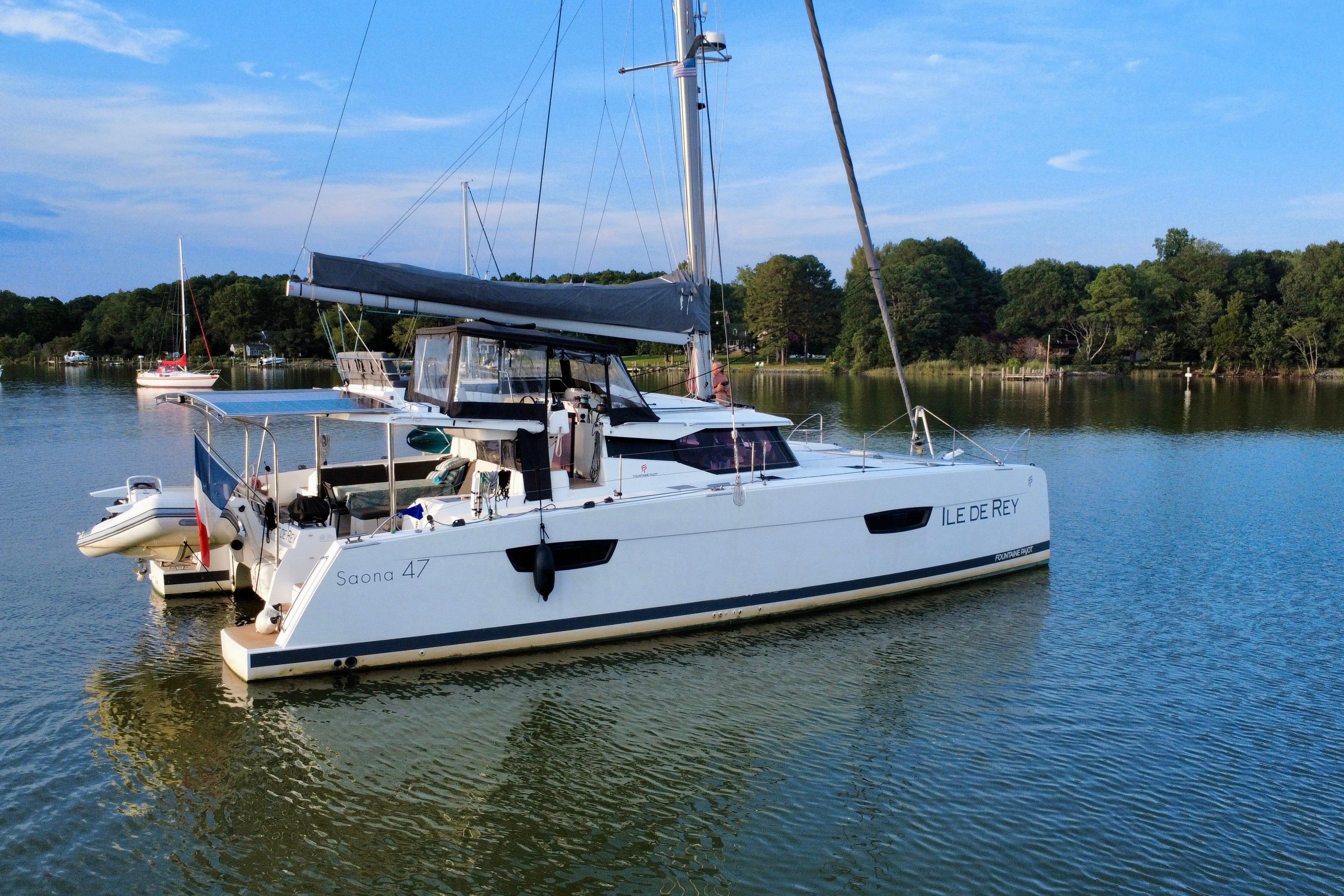 2020 Fountaine Pajot Saona 47 catamaran anchored on serene lake with lush green backdrop.