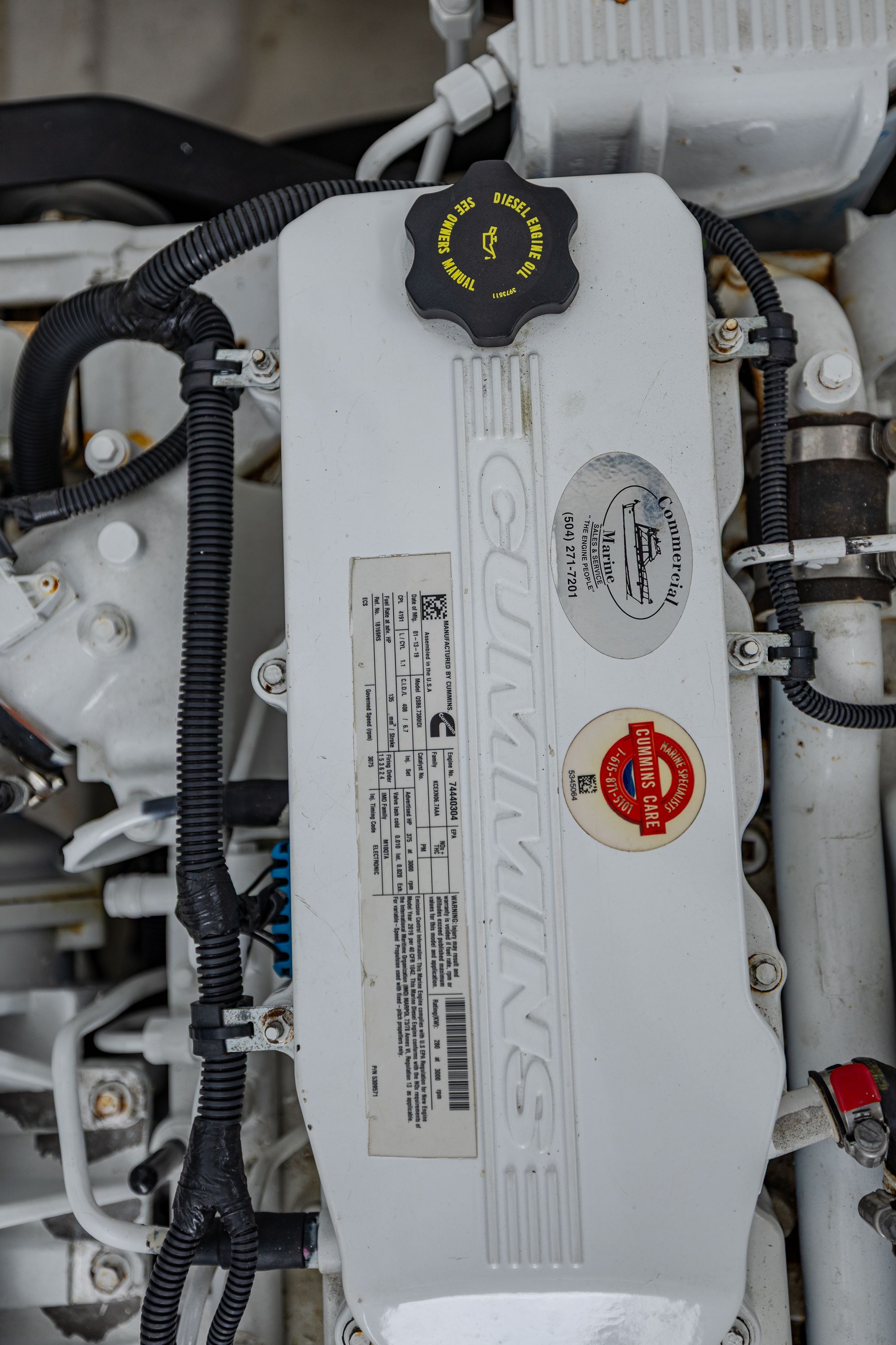Close-up of a Cummins engine with stickers and cables.