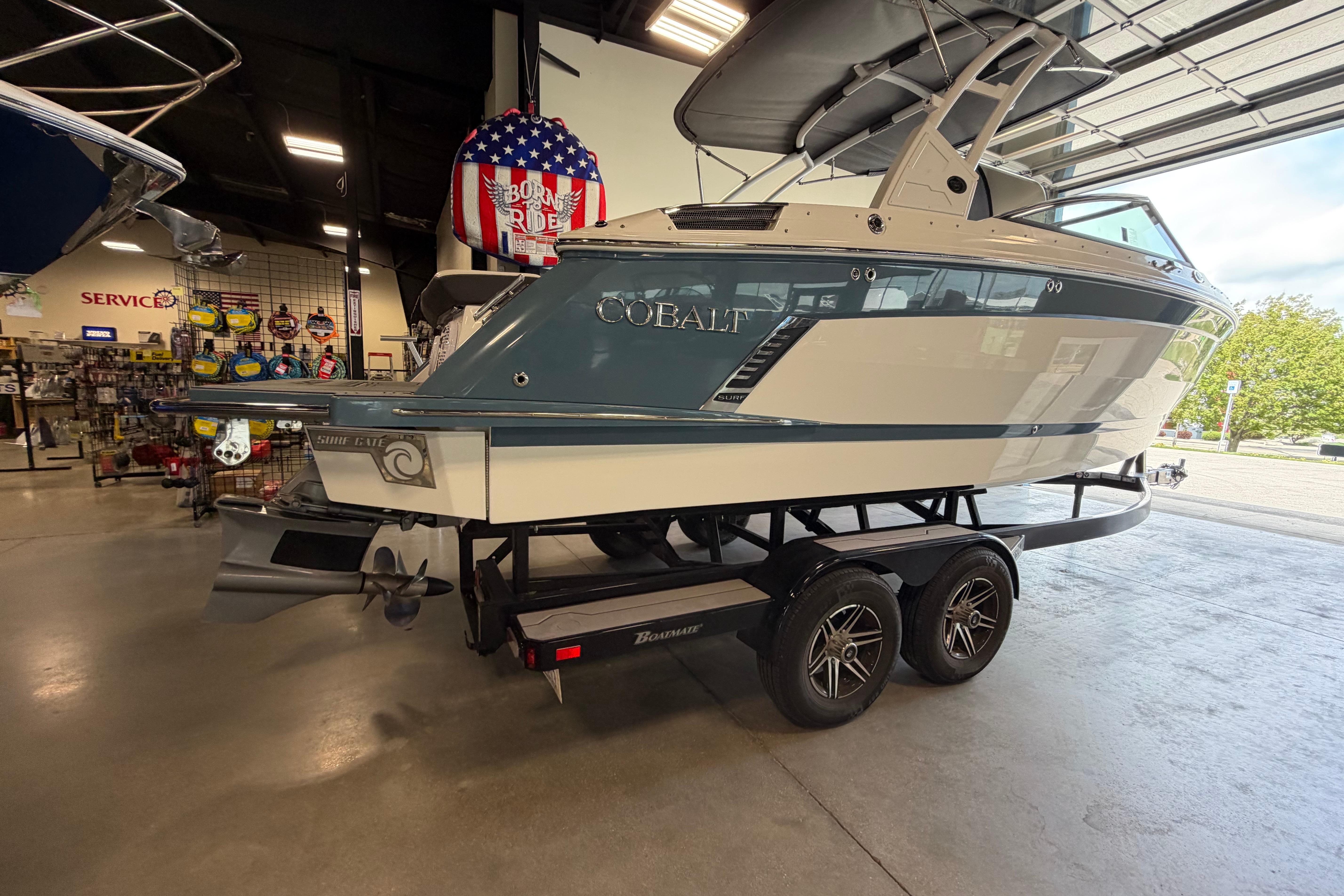 2022 Cobalt R6 Surf boat on trailer in showroom, featuring sleek design and modern features.