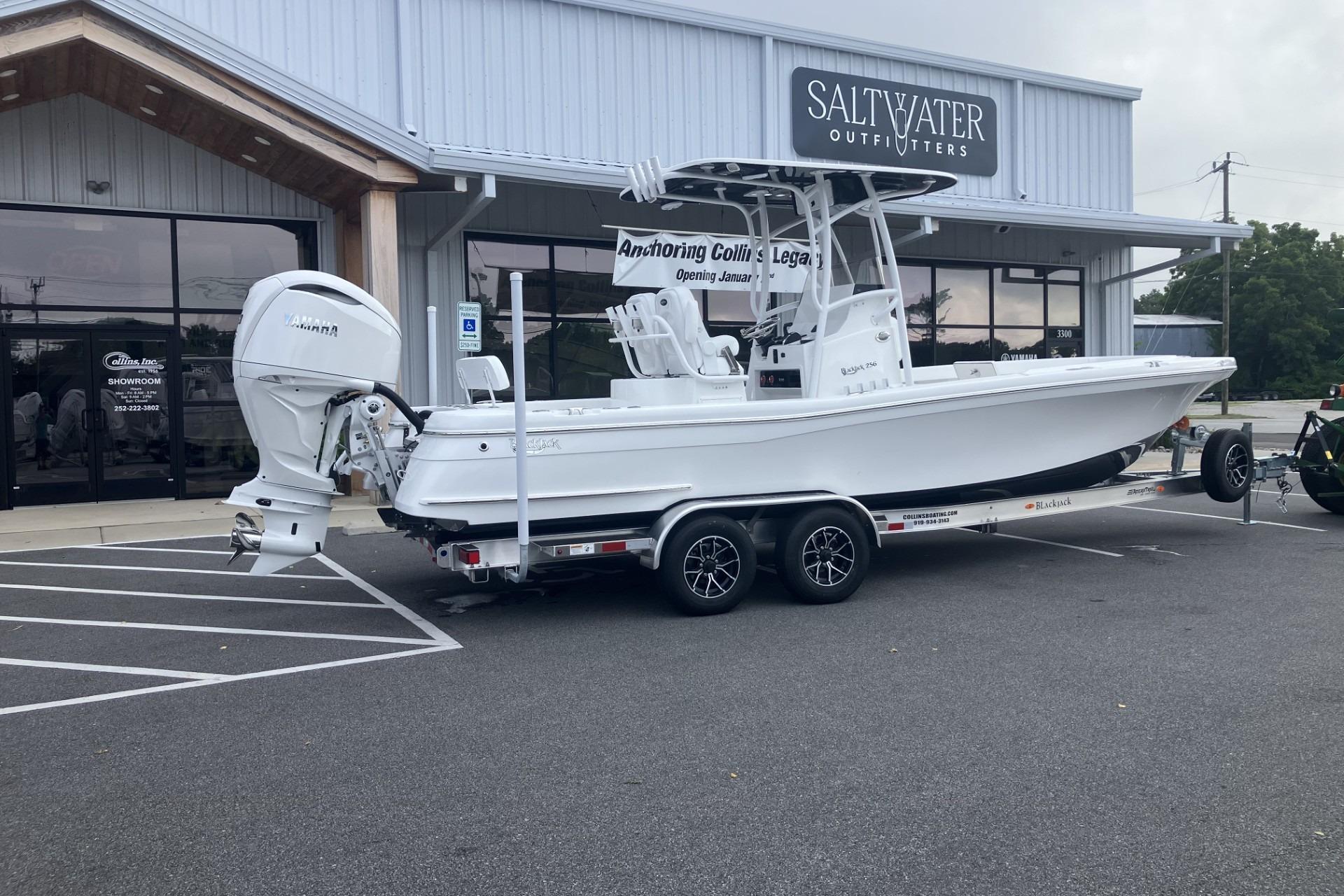2026 BlackJack 256 Coastal boat on trailer outside Saltwater Outfitters showroom.