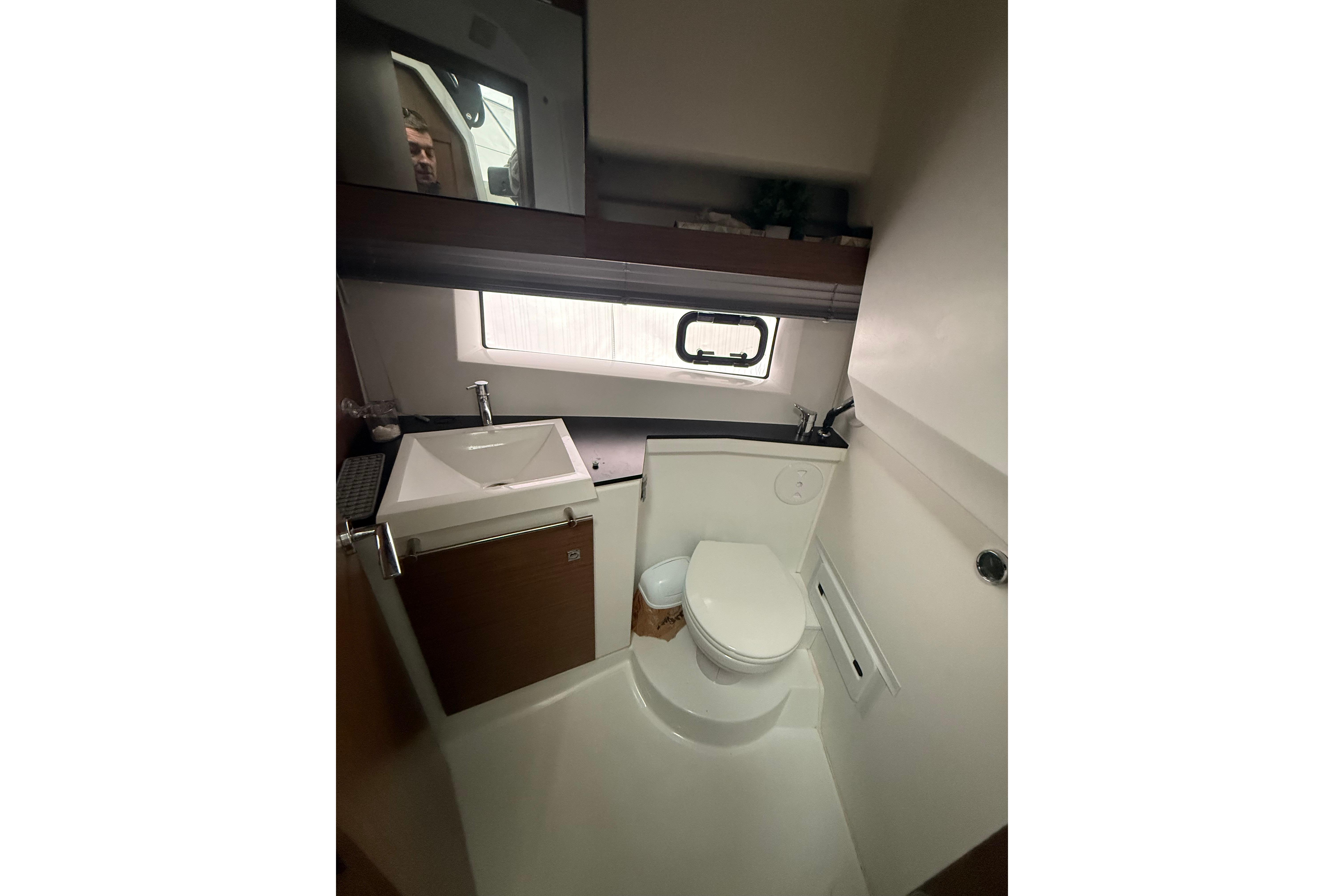 2019 Jeanneau NC 9 boat bathroom with sink, toilet, and window.