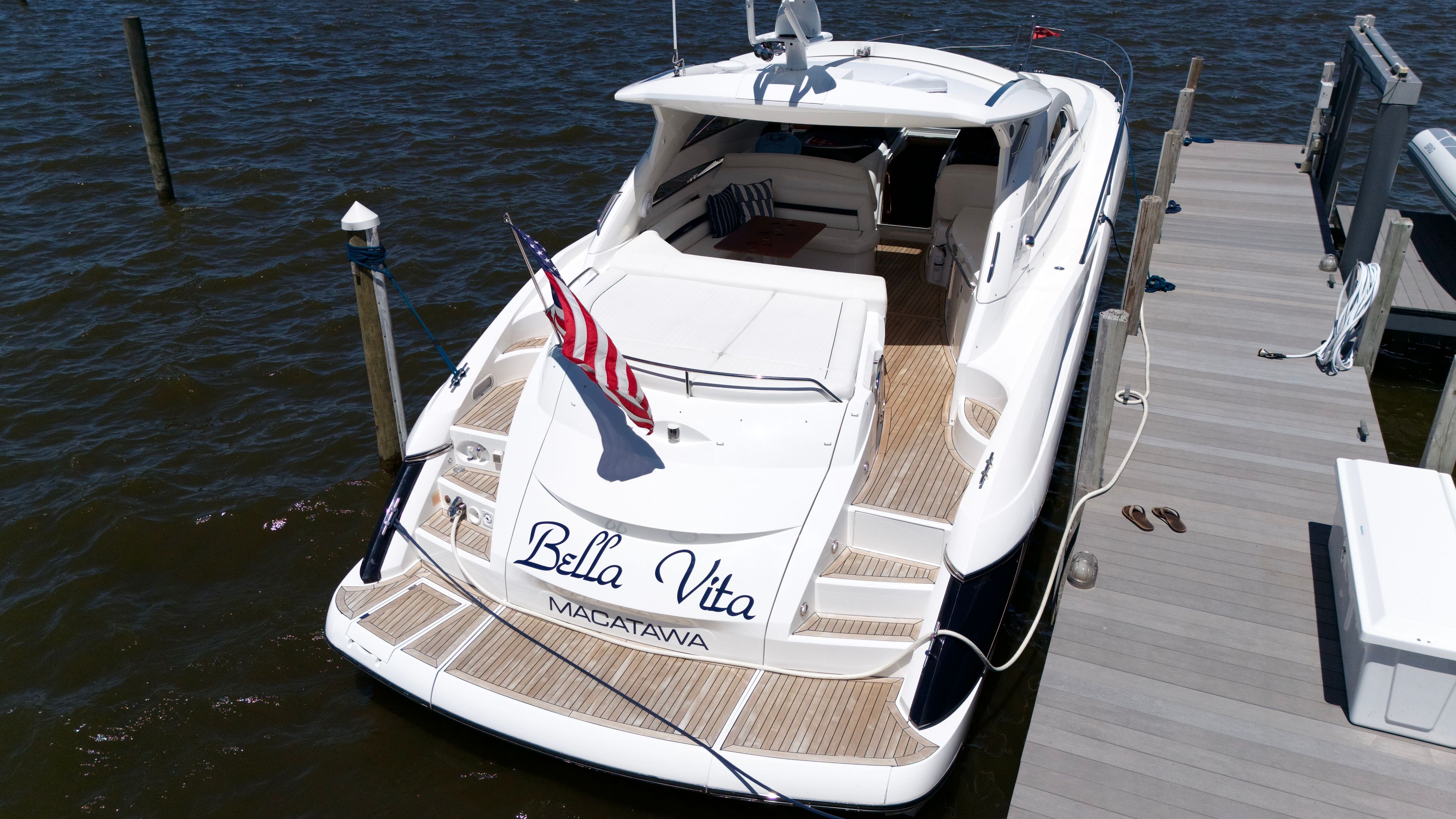 A luxurious 2008 Sunseeker Portofino 53 yacht docked, featuring an American flag.