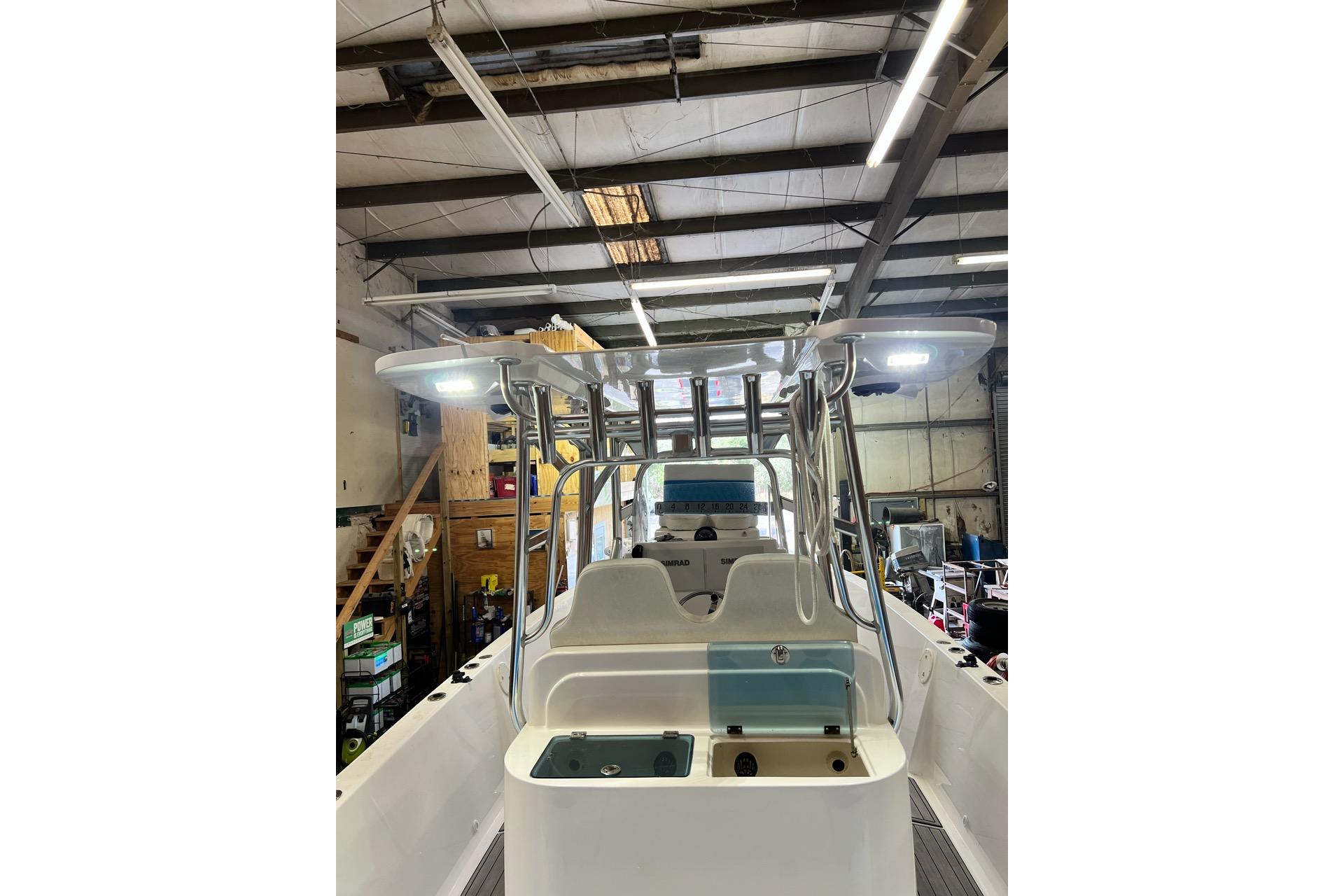 Custom Infusion 34 CC 2021 boat in a workshop, showcasing helm and seating area.