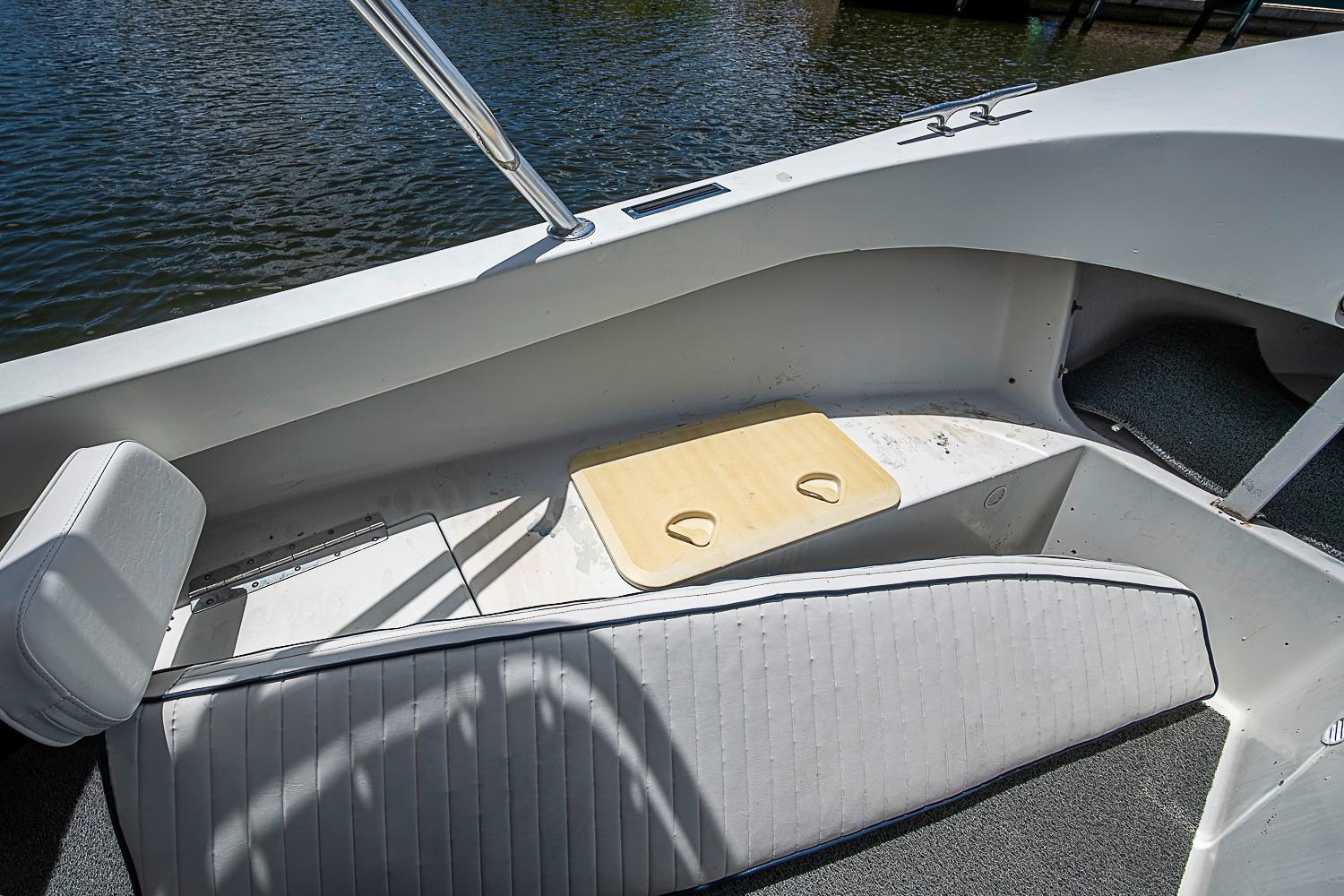 Interior of a 1969 custom boat with seating and cup holders by the water.
