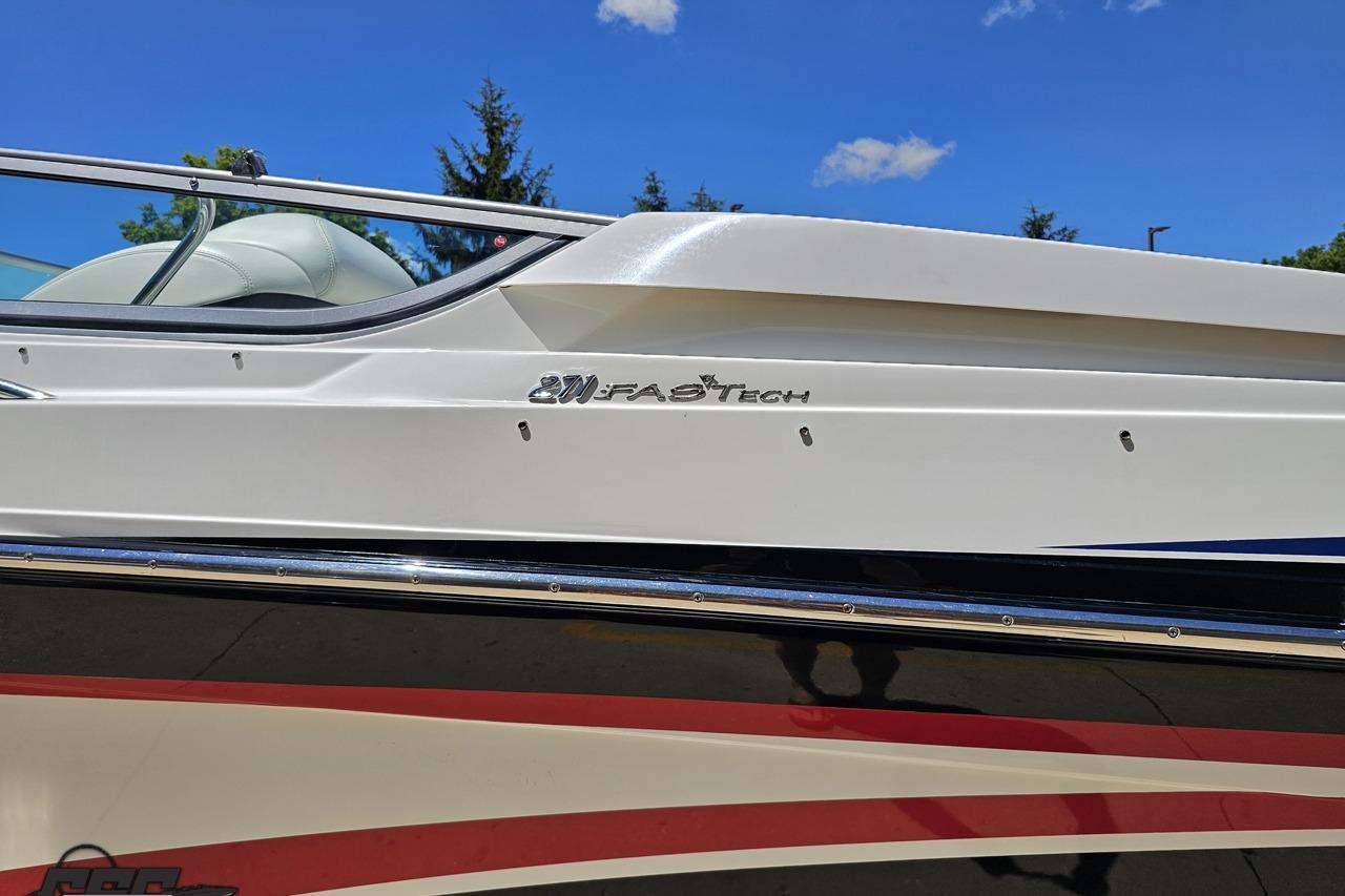 2005 Formula 271 FASTech boat side view with logo, under clear blue sky.