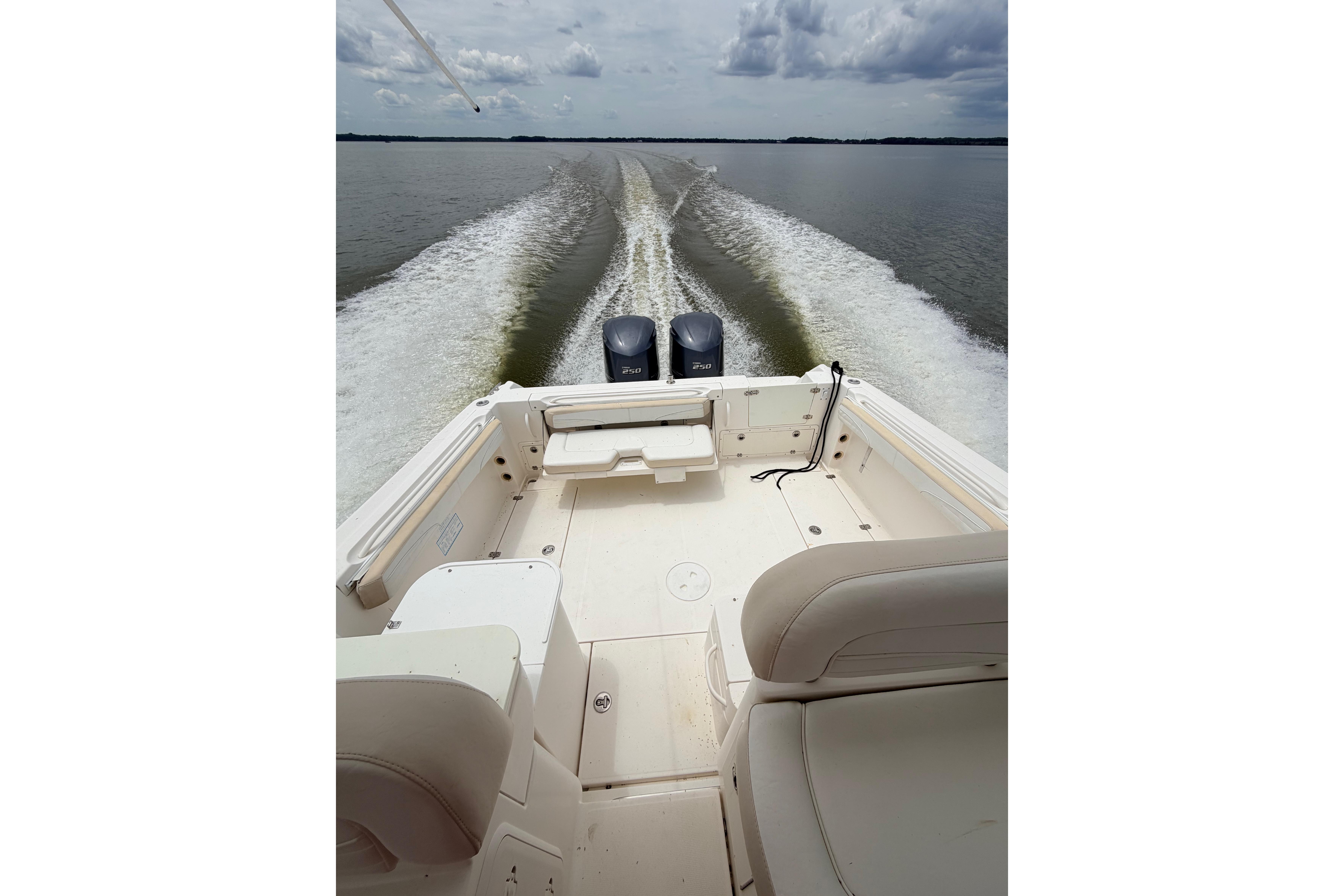 2015 Wellcraft 290 Coastal boat cruising on open water, leaving a wake behind.