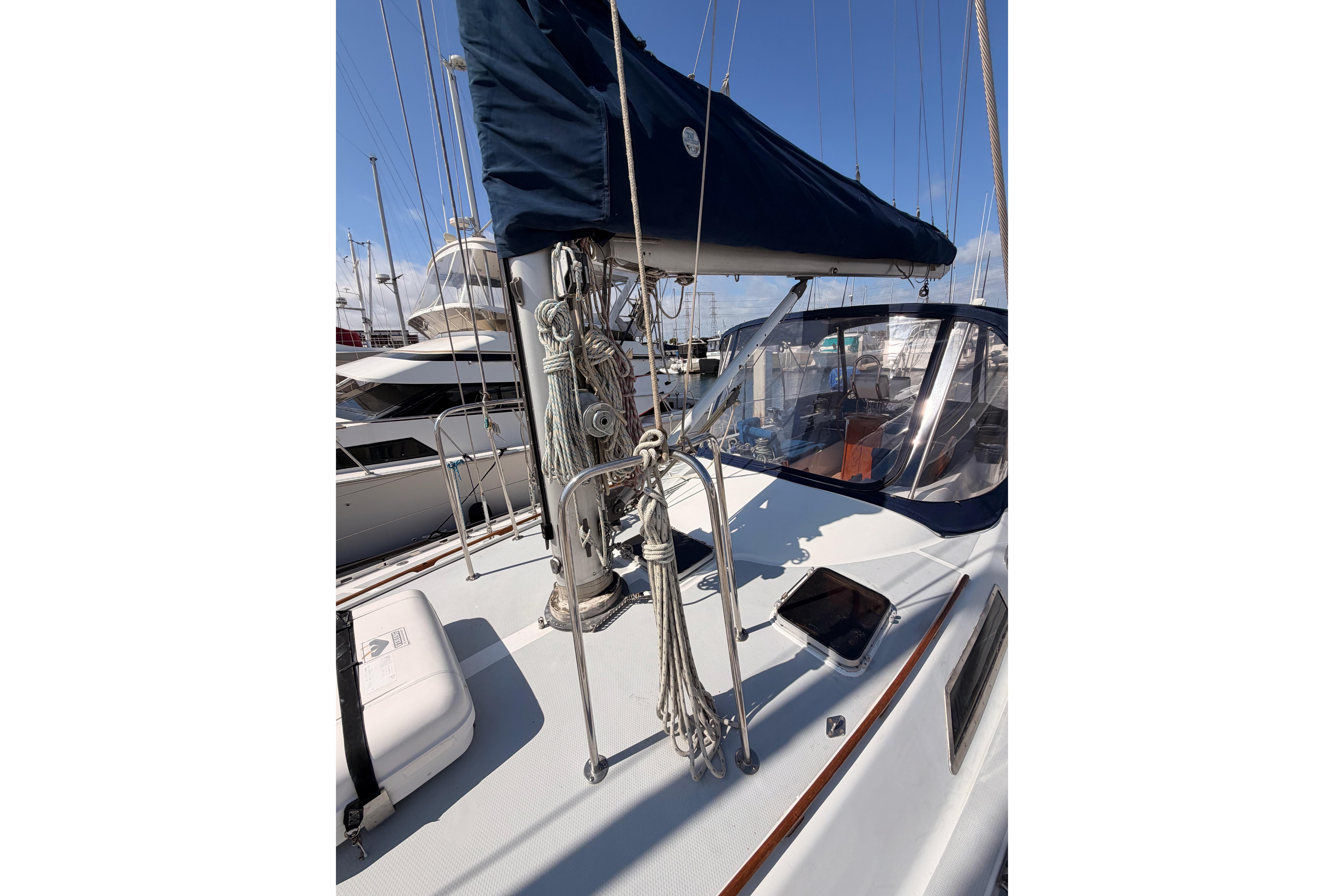 Sailboat deck of 1991 Hylas 51 with rigging and canopy in marina.